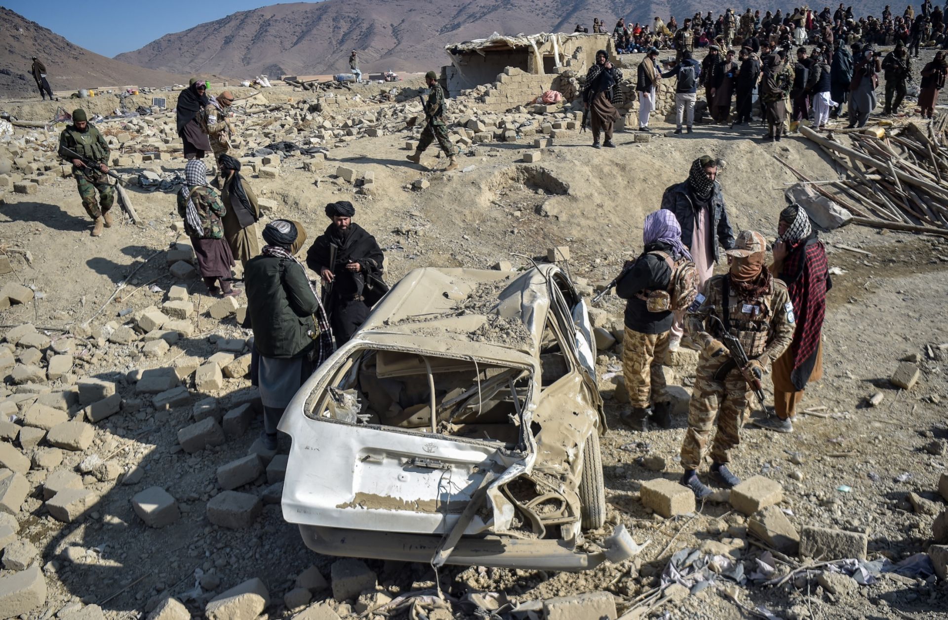 Taliban security personnel inspect a car damaged by Pakistani air strikes in Afghanistan's eastern Paktika province on Dec. 26, 2024. 