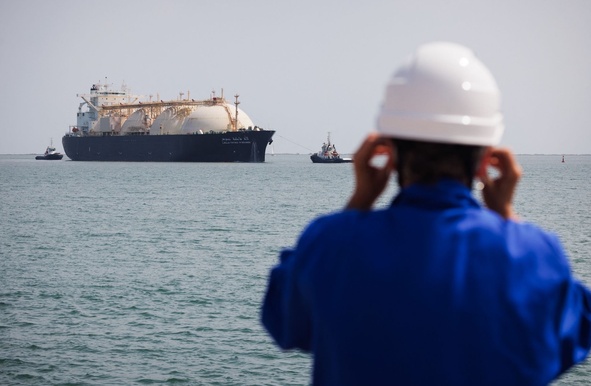 A worker stands on the uploading dock of Cavaou LNG terminal in Fos-sur-Mer, France, on June 22, 2023, while the tanker boat "Lalla Fatma N'Soumer" arrives full of LNG ready to be delivered. 