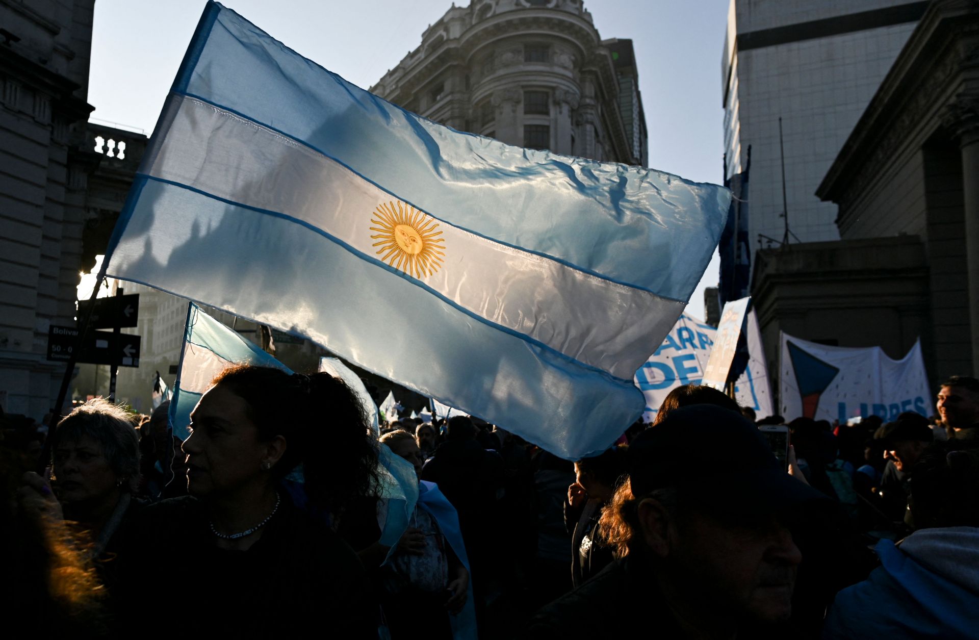 Anti-government protesters hold up the Argentine flag during a rally outside the presidential palace in Buenos Aires on July 9, 2022.