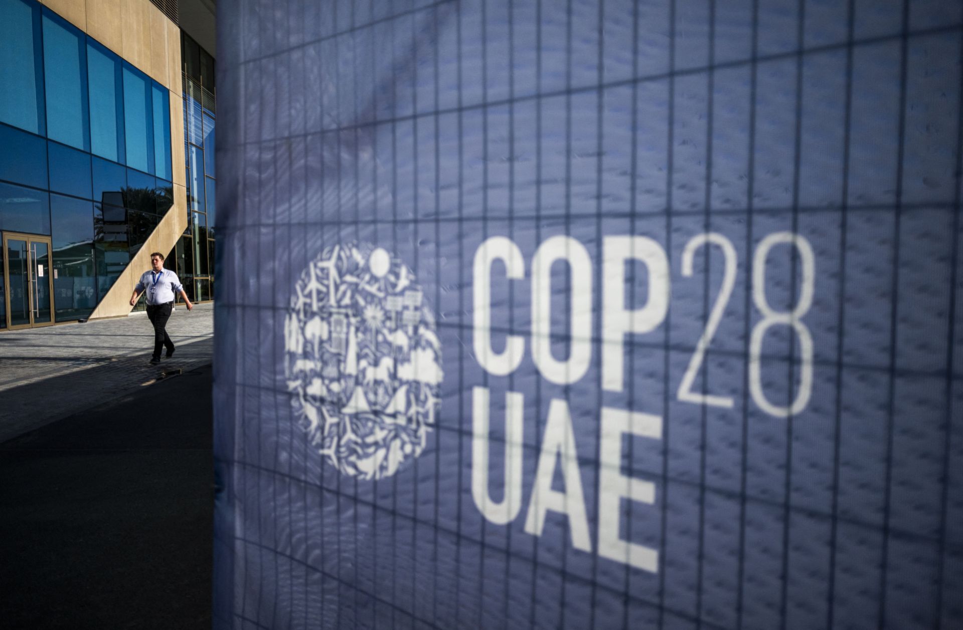 A man walks past a COP28 sign at the venue of the U.N. climate summit in Dubai on Nov. 30, 2023. 