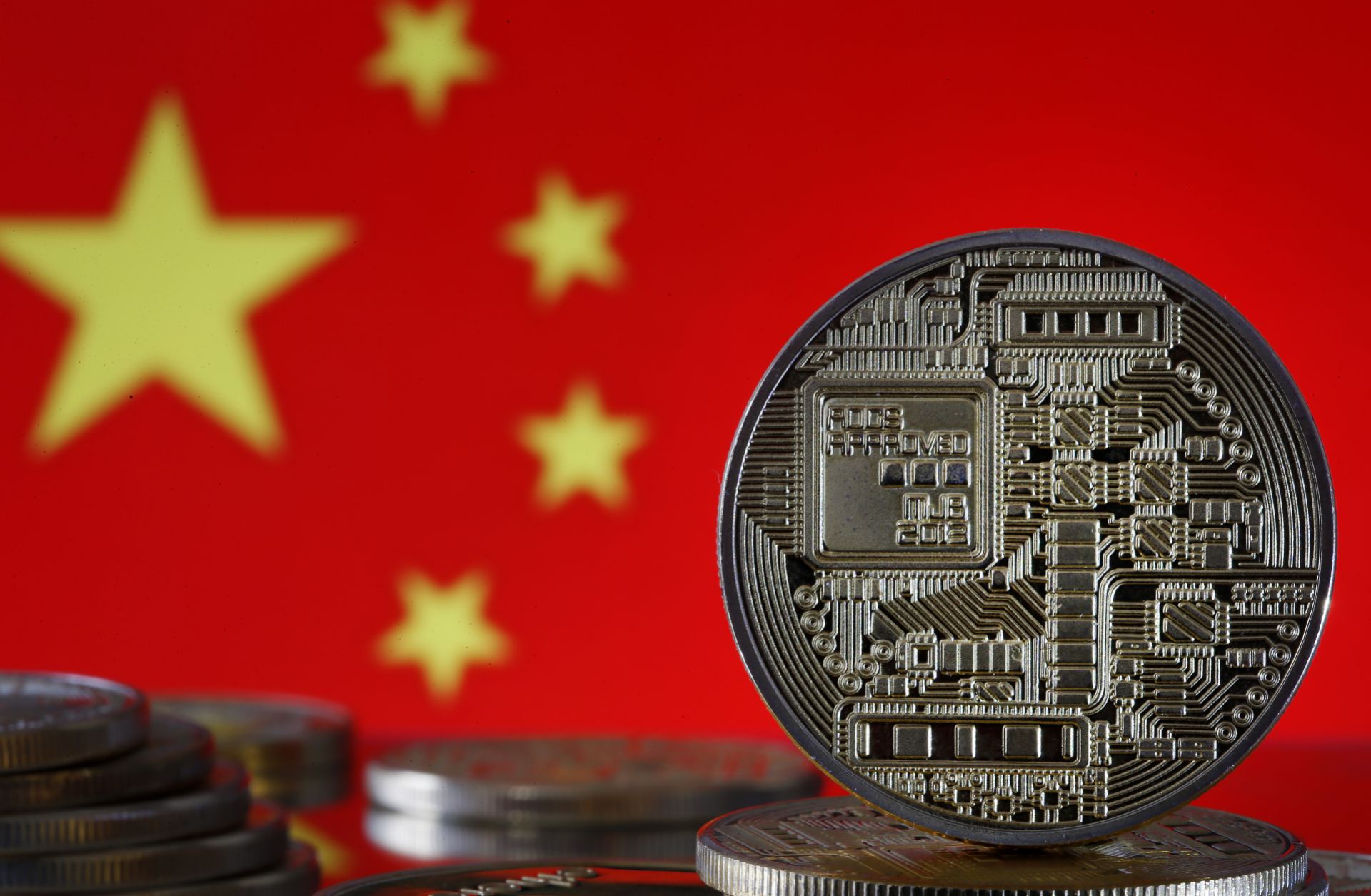 A photo illustration shows digital currency coins in front of a Chinese flag in October 2019.