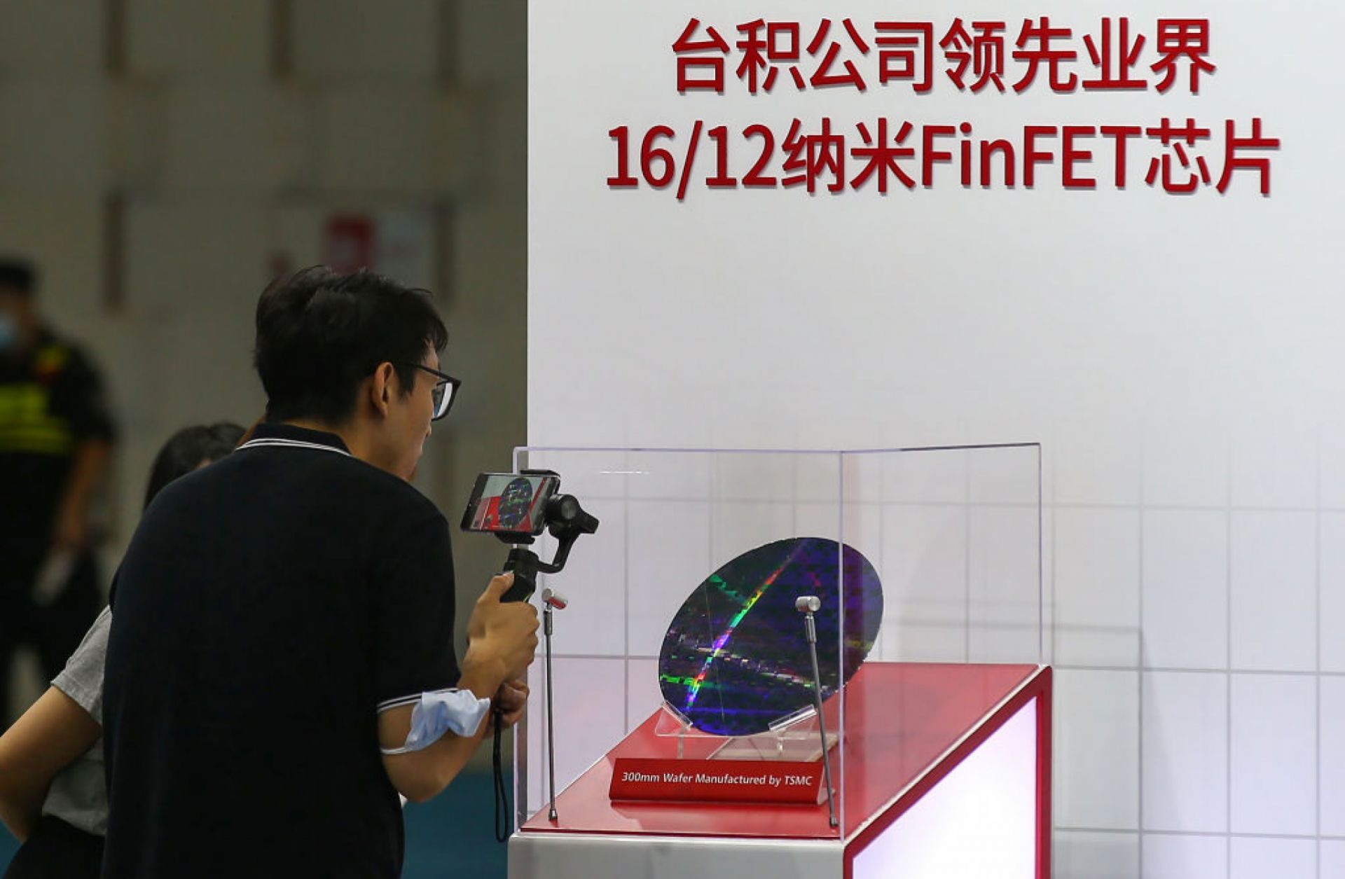 A visitor takes photos at the 2020 World Semiconductor Conference on Aug. 26, 2020, in Nanjing in China's eastern Jiangsu province of a chip made by Taiwan Semiconductor Manufacturing Co.