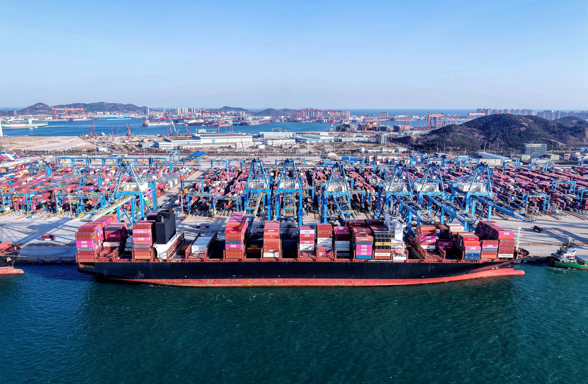 Cranes unload shipping containers from a ship at a port in Qingdao, in eastern China's Shandong province, on April 2, 2025. 