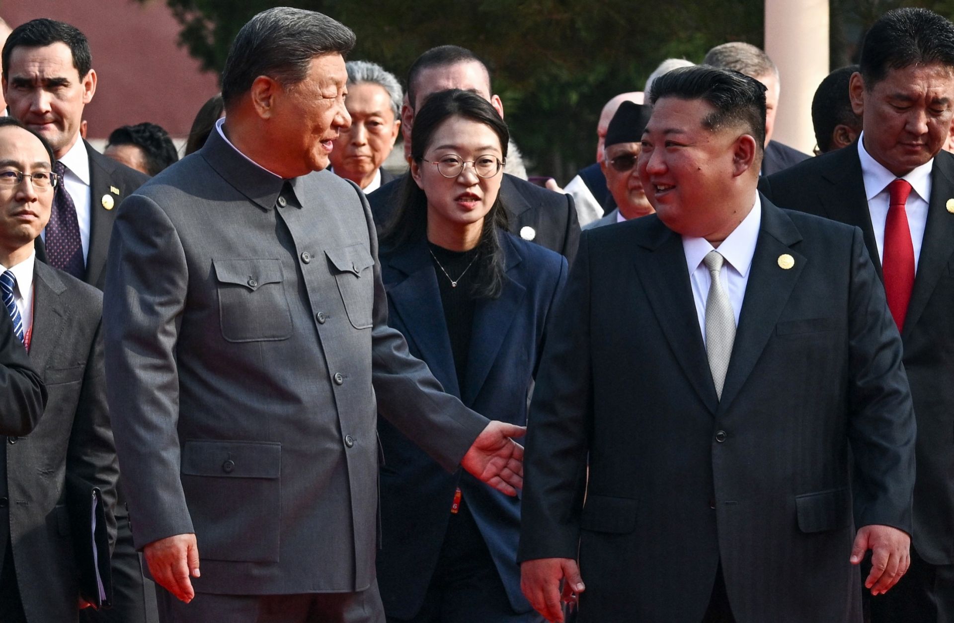 Chinese President Xi Jinping (left) gestures to North Korean leader Kim Jong Un before a military parade in Beijing's Tiananmen Square on Sept. 3, 2025.