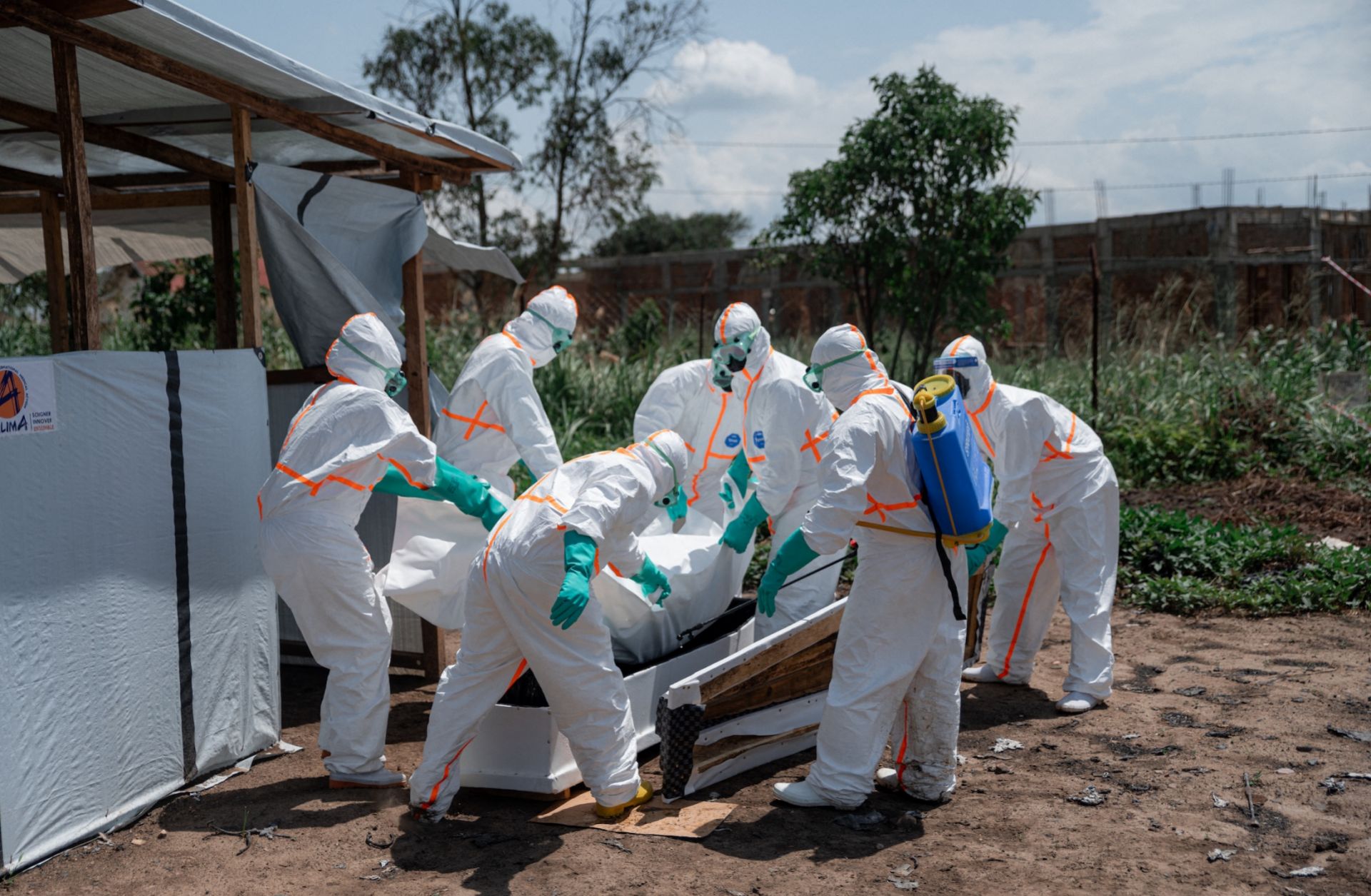 Red Cross volunteers wearing personal protective equipment lower the body of an Ebola victim into a casket at a health center in Ituri province, Democratic Republic of Congo, on June 8, 2026. Red Cross volunteers wearing personal protective equipment lower the body of an Ebola victim into a casket at a health center in Ituri province, Democratic Republic of Congo, on June 8, 2026.