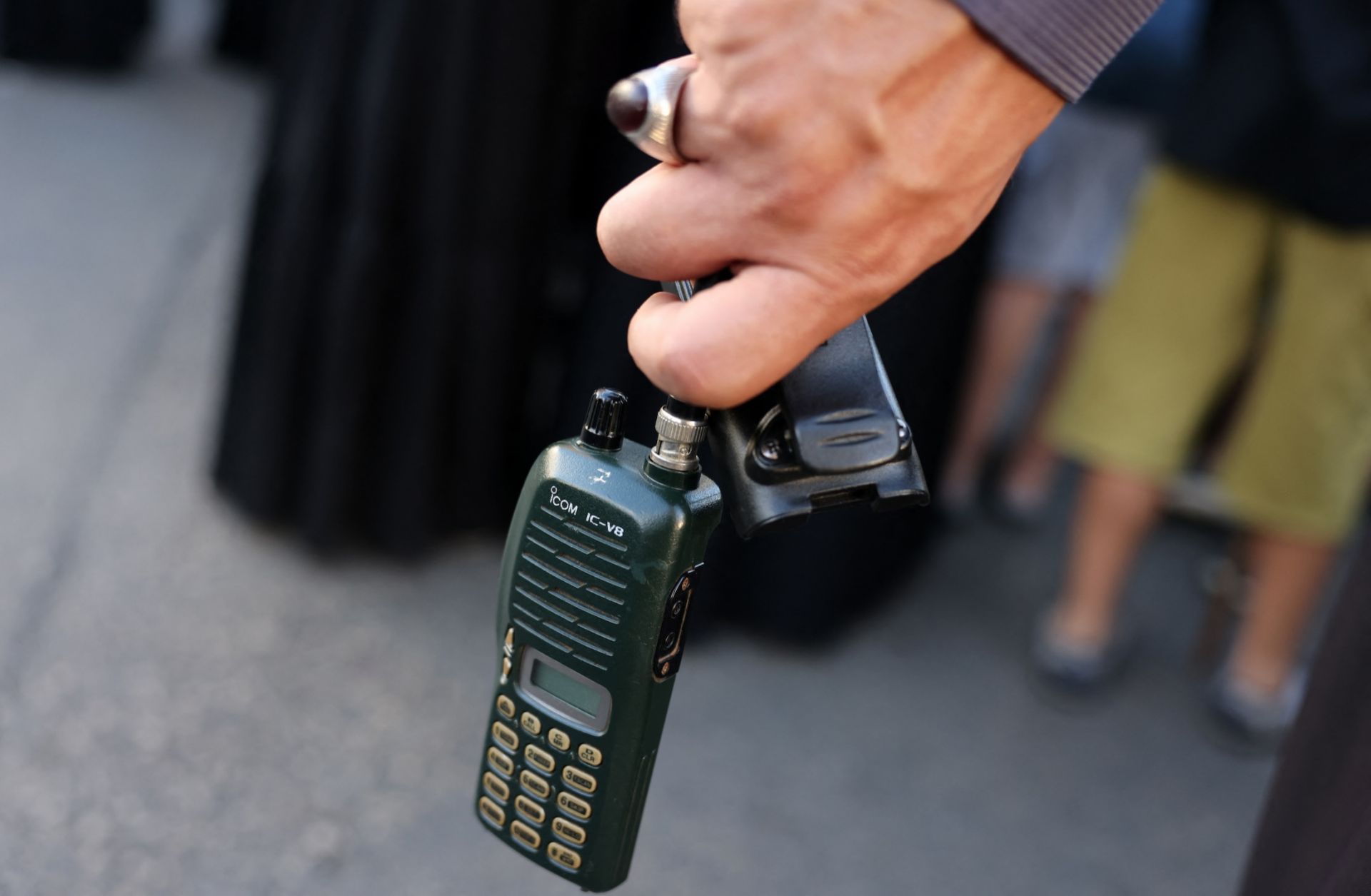 A man in Beirut, Lebanon, holds a walkie-talkie after removing its battery on Sept. 18, 2024, during a funeral for people killed when hundreds of paging devices exploded across the country the previous day. 