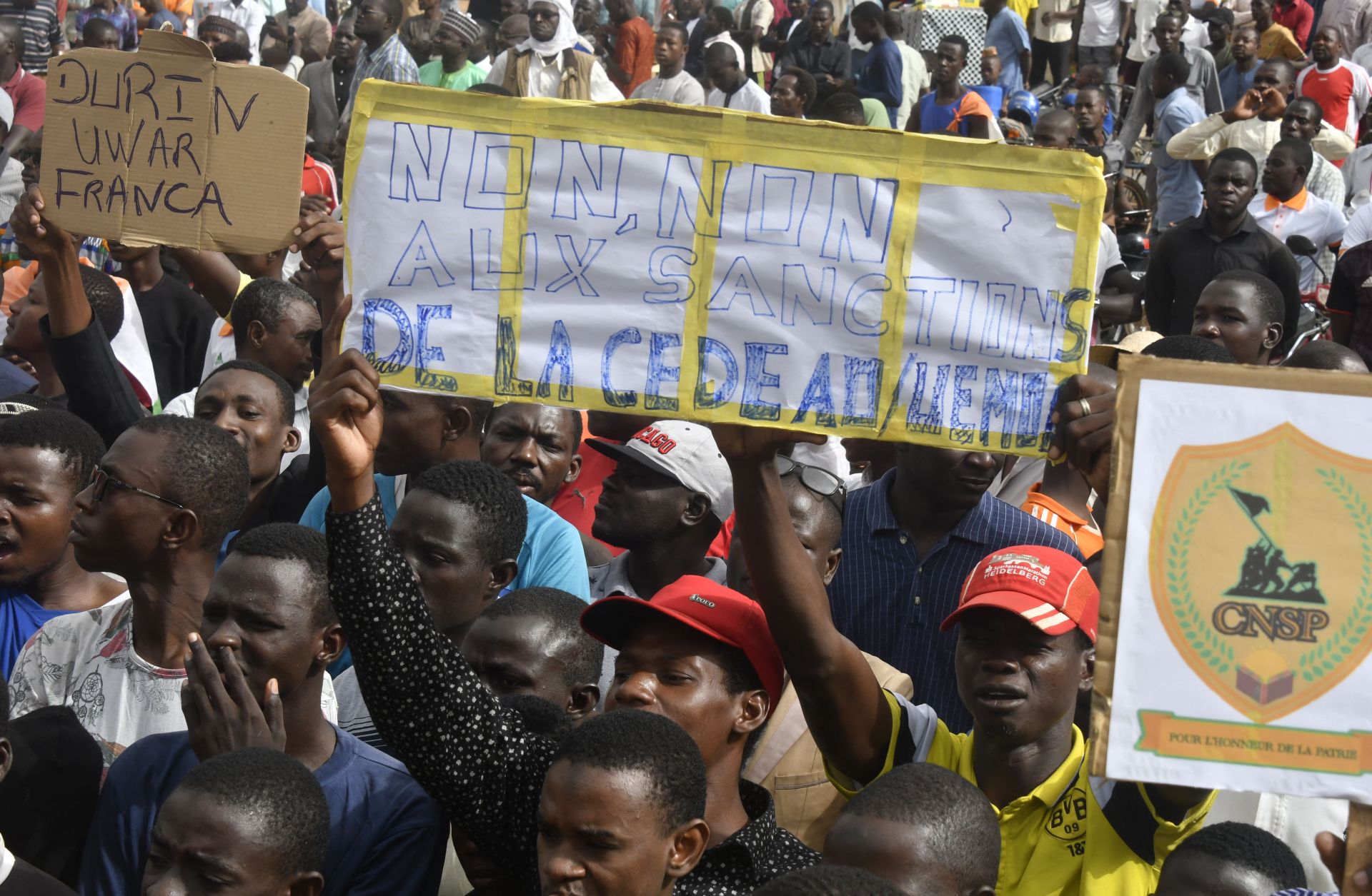 Protesters hold placards denouncing ECOWAS on Aug. 3, 2023, in Niamey, Niger.