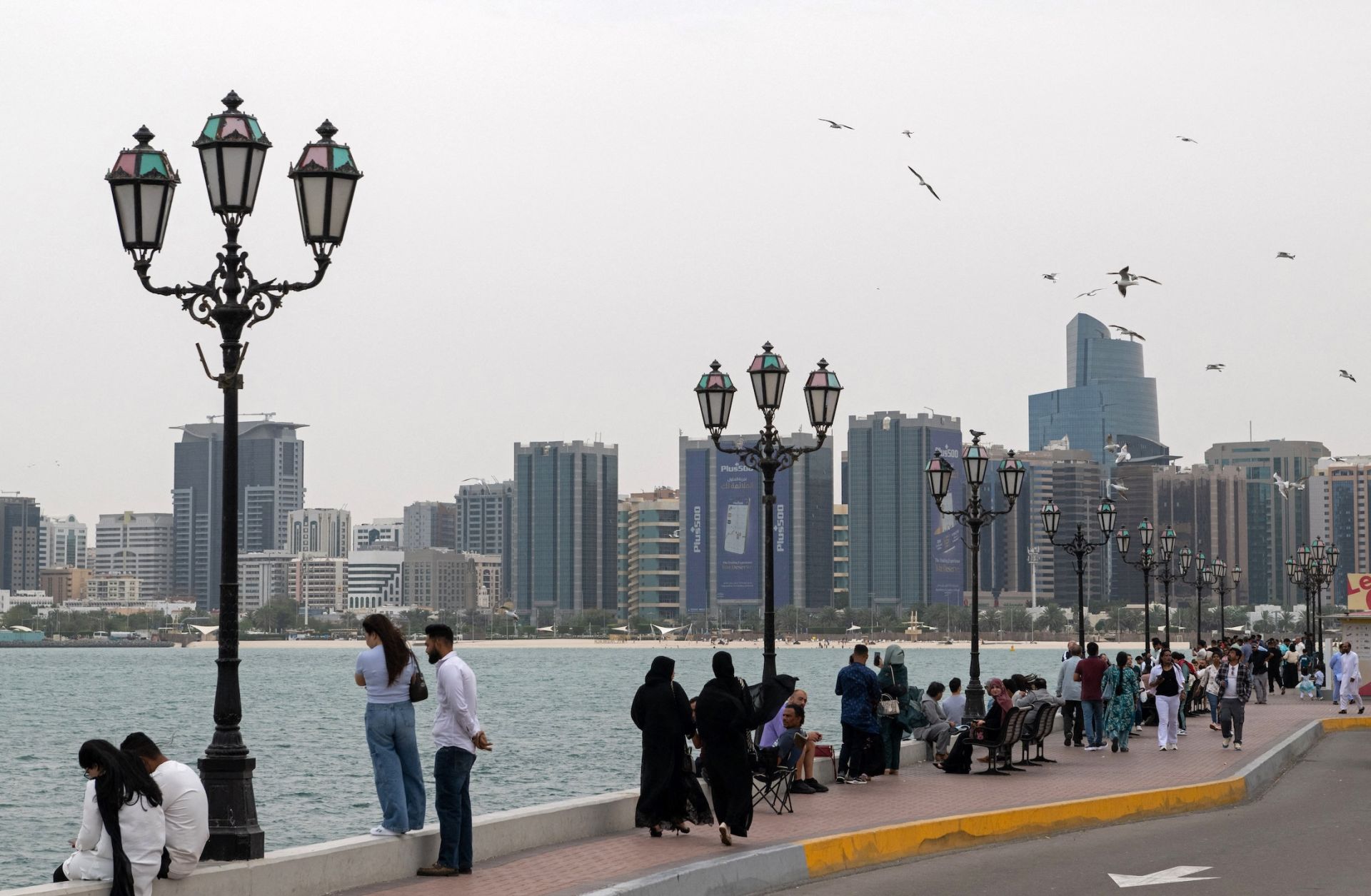 People walk along the corniche area on the occasion of Eid al-Fitr, marking the end of the holy month of Ramadan, in Abu Dhabi on March 20, 2026.