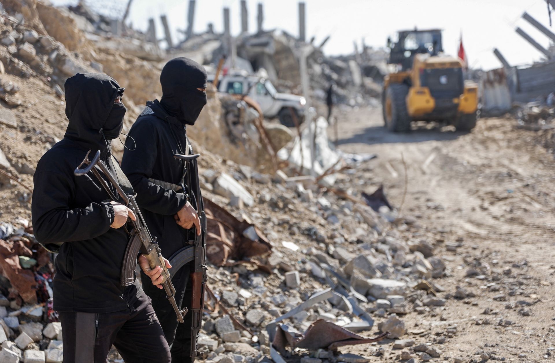 Palestinian Hamas militants stand guard as Egyptian and Red Cross workers search for the bodies of the last two remaining hostages from under the rubble of the Jabalia refugee camp, in the northern Gaza Strip, on Dec. 1, 2025. Palestinian Hamas militants stand guard as Egyptian and Red Cross workers search for the bodies of the last two remaining hostages from under the rubble of the Jabalia refugee camp, in the northern Gaza Strip, on Dec. 1, 2025.