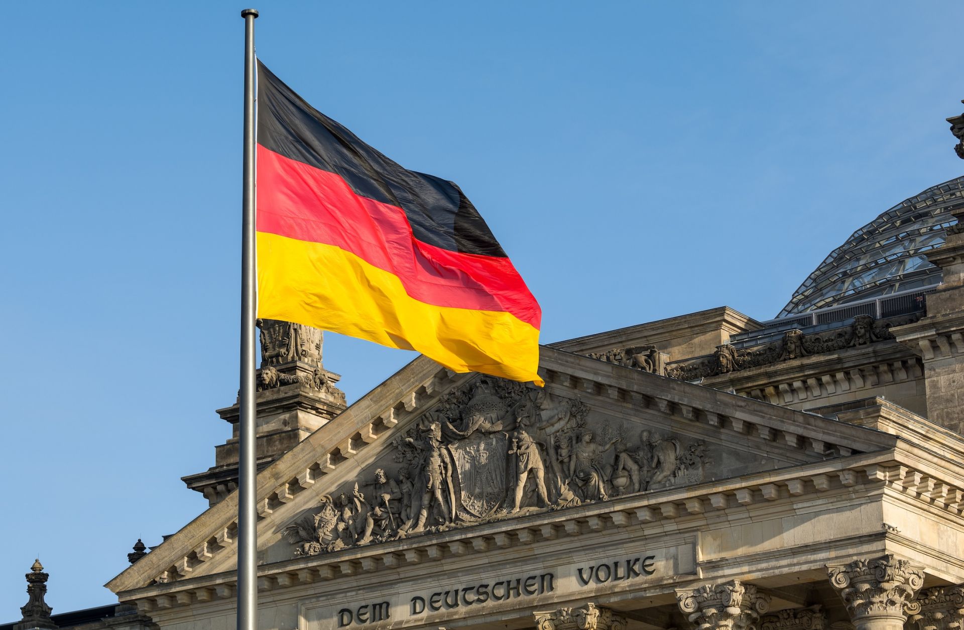 A German flag flutters in front of the Reichstag building in Berlin, Germany. 