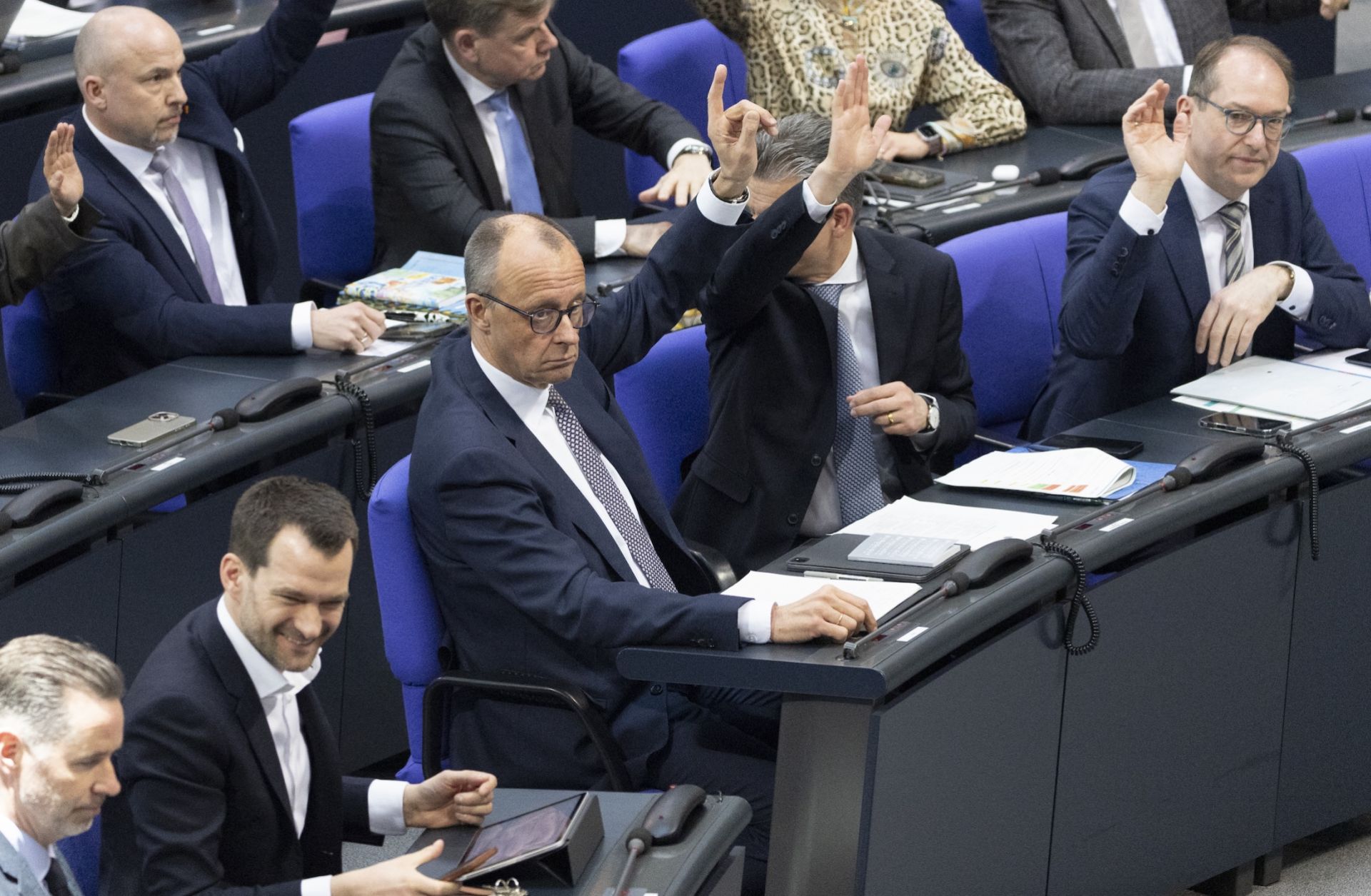 Chancellor Friedrich Merz raises his hand in a vote at the Bundestag prior to a vote on changes to Germany's Basic Law on March 18, 2025 in Berlin, Germany.  Chancellor Friedrich Merz raises his hand in a vote at the Bundestag prior to a vote on changes to Germany's Basic Law on March 18, 2025 in Berlin, Germany.