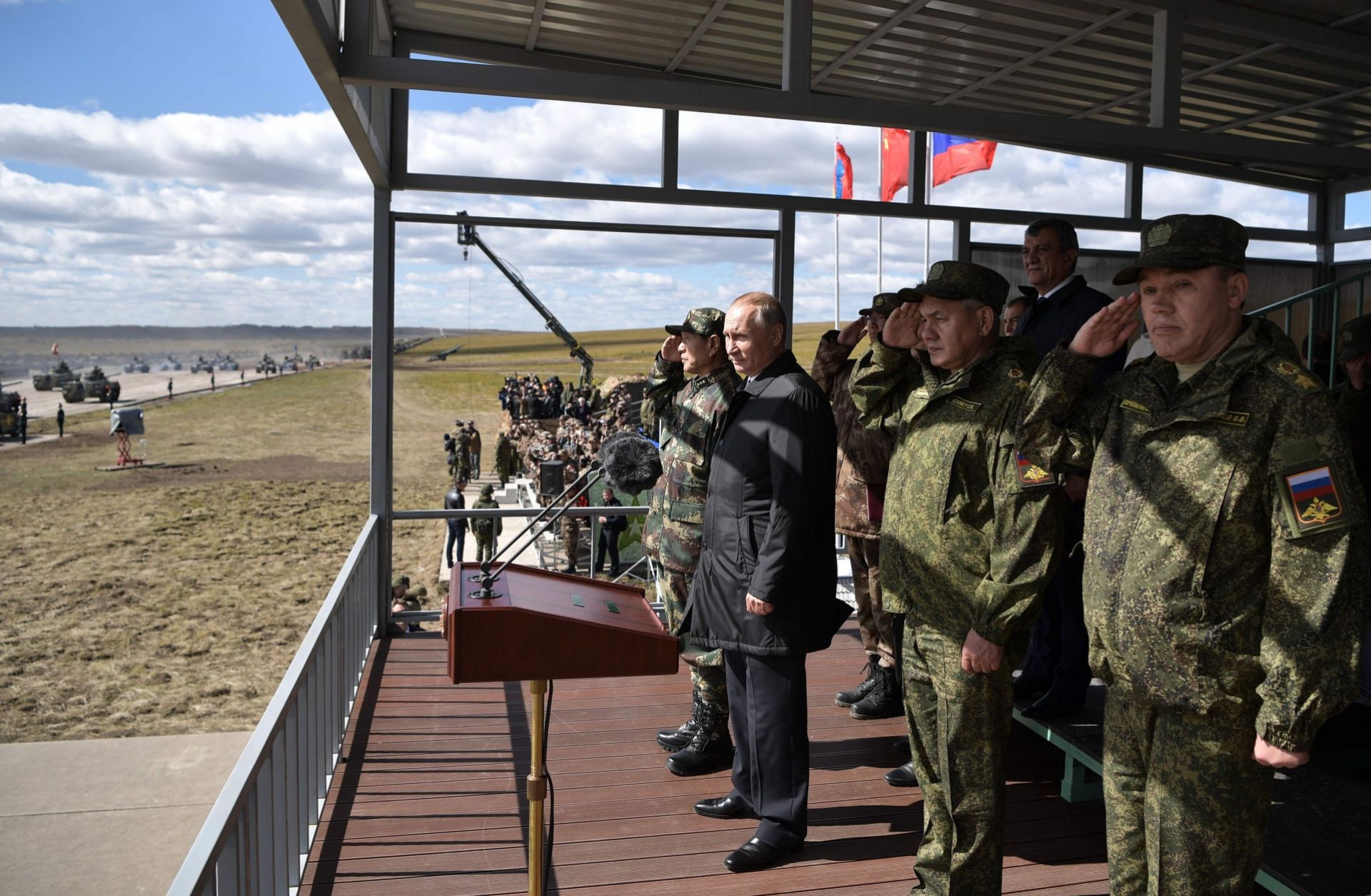 Russian and Chinese defense officials surround Russian President Vladimir Putin as he watches a military parade at a training ground in Siberia on Sept. 13, 2018.
