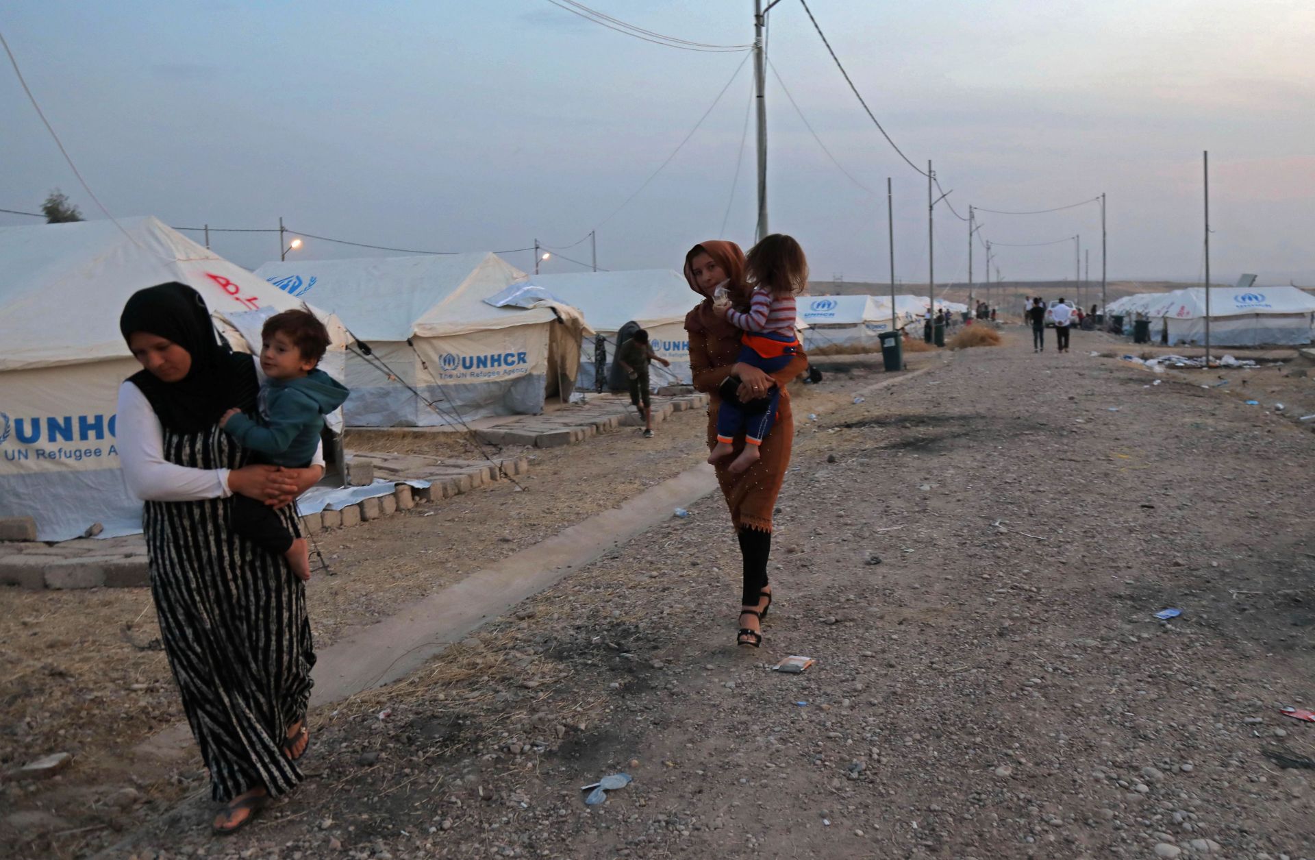 Syrian refugees walk outside a tent at a camp near the Iraqi Kurdish town of Bardarash on Oct. 18, 2019. Syrian refugees walk outside a tent at a camp near the Iraqi Kurdish town of Bardarash on Oct. 18, 2019.