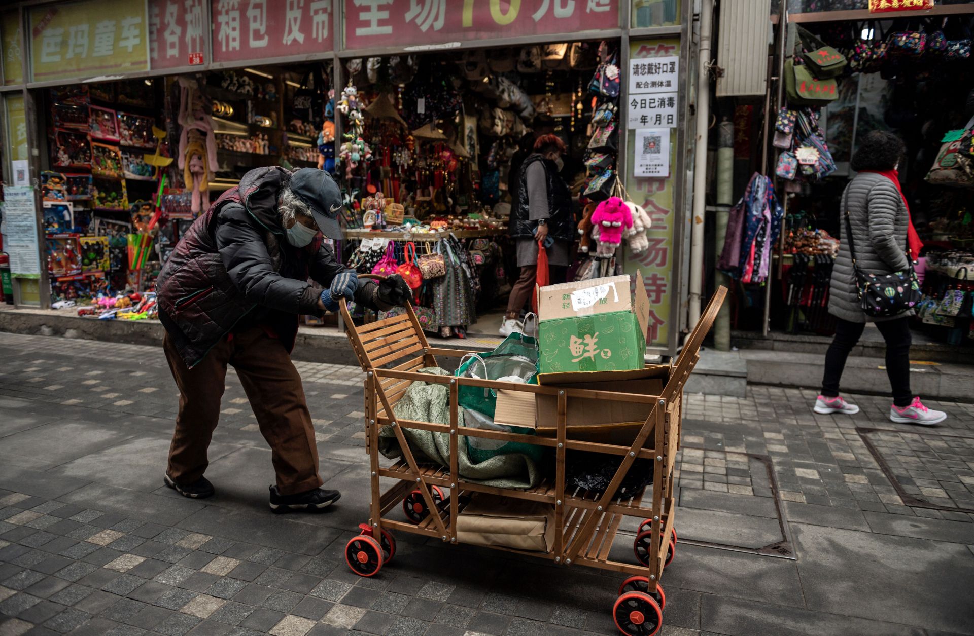 A woman pushes a cart down a street in Beijing, China, on March 5, 2021. A woman pushes a cart down a street in Beijing, China, on March 5, 2021.