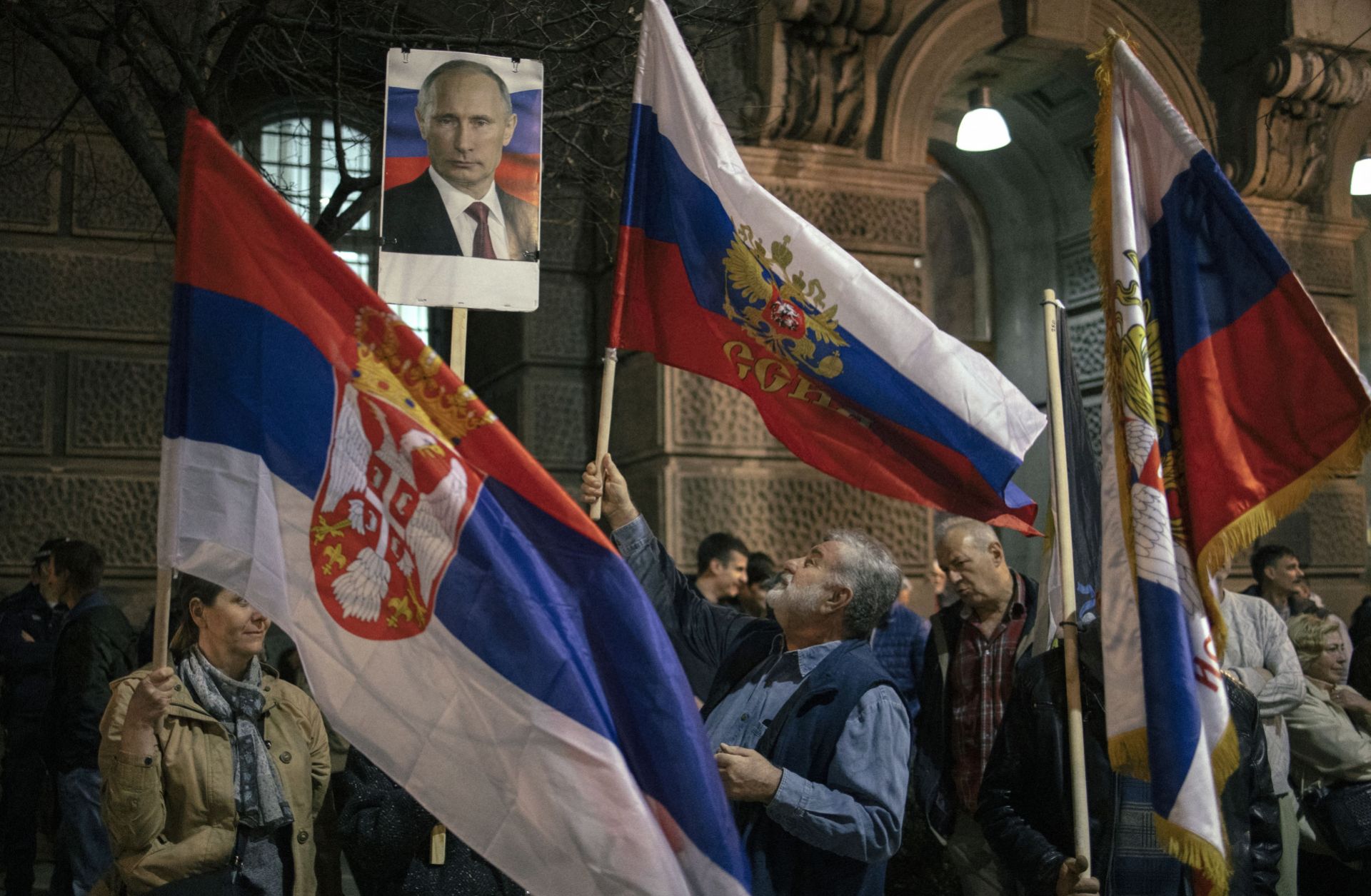 Demonstrators in Belgrade, Serbia, hold up Serbian flags and a photo of Russian President Vladimir Putin on March 24, 2022, during a rally in support of the Russian invasion of Ukraine. 