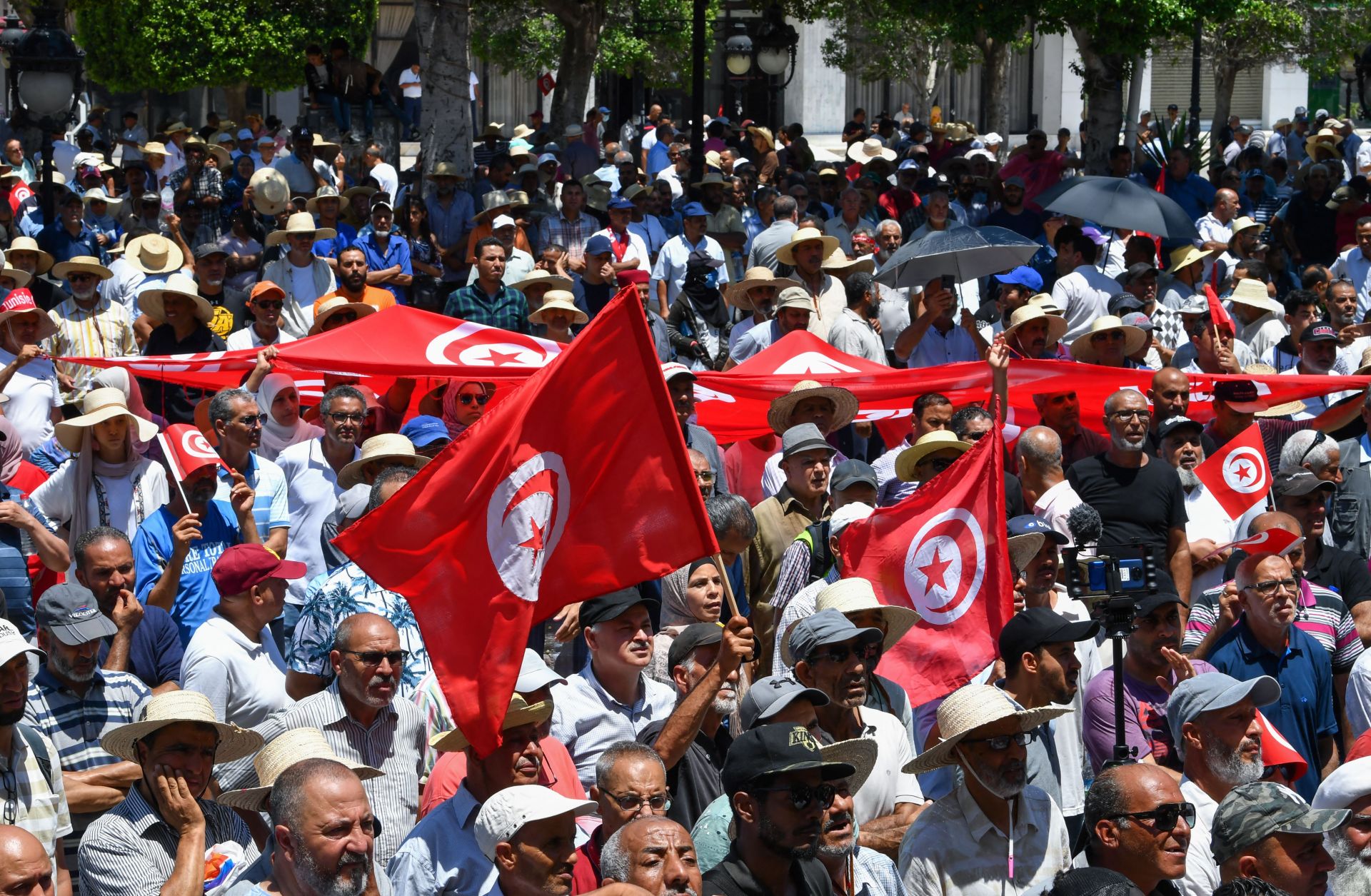 Demonstrators in Tunis, Tunisia, lift national flags during a protest on June 19, 2022, against President Kais Saied and the country’s upcoming constitutional referendum. 