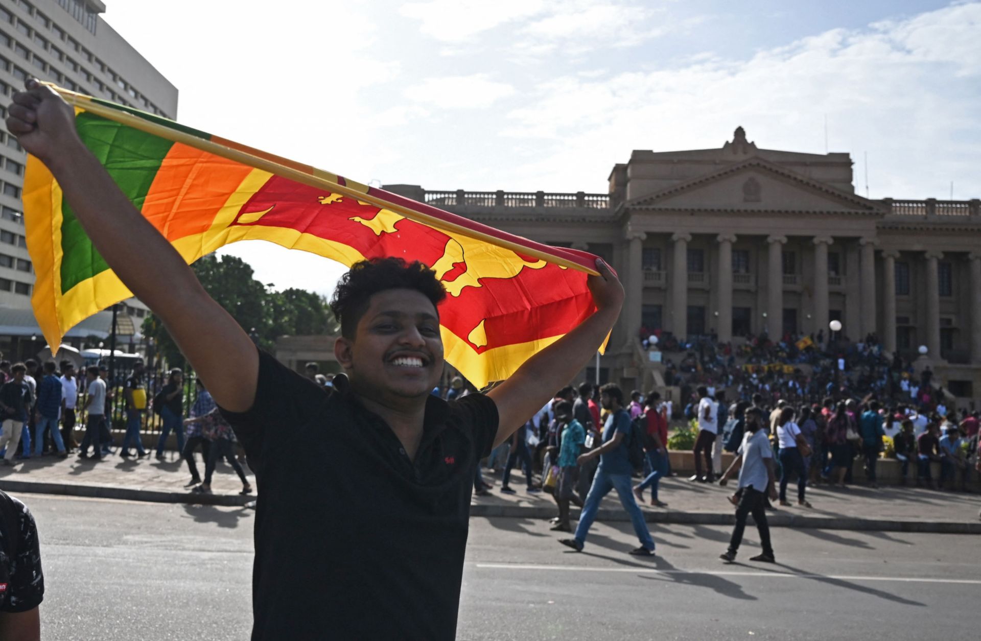 A protester waves Sri Lanka's national flag outside the presidential palace in Colombo on July 13, 2022. 