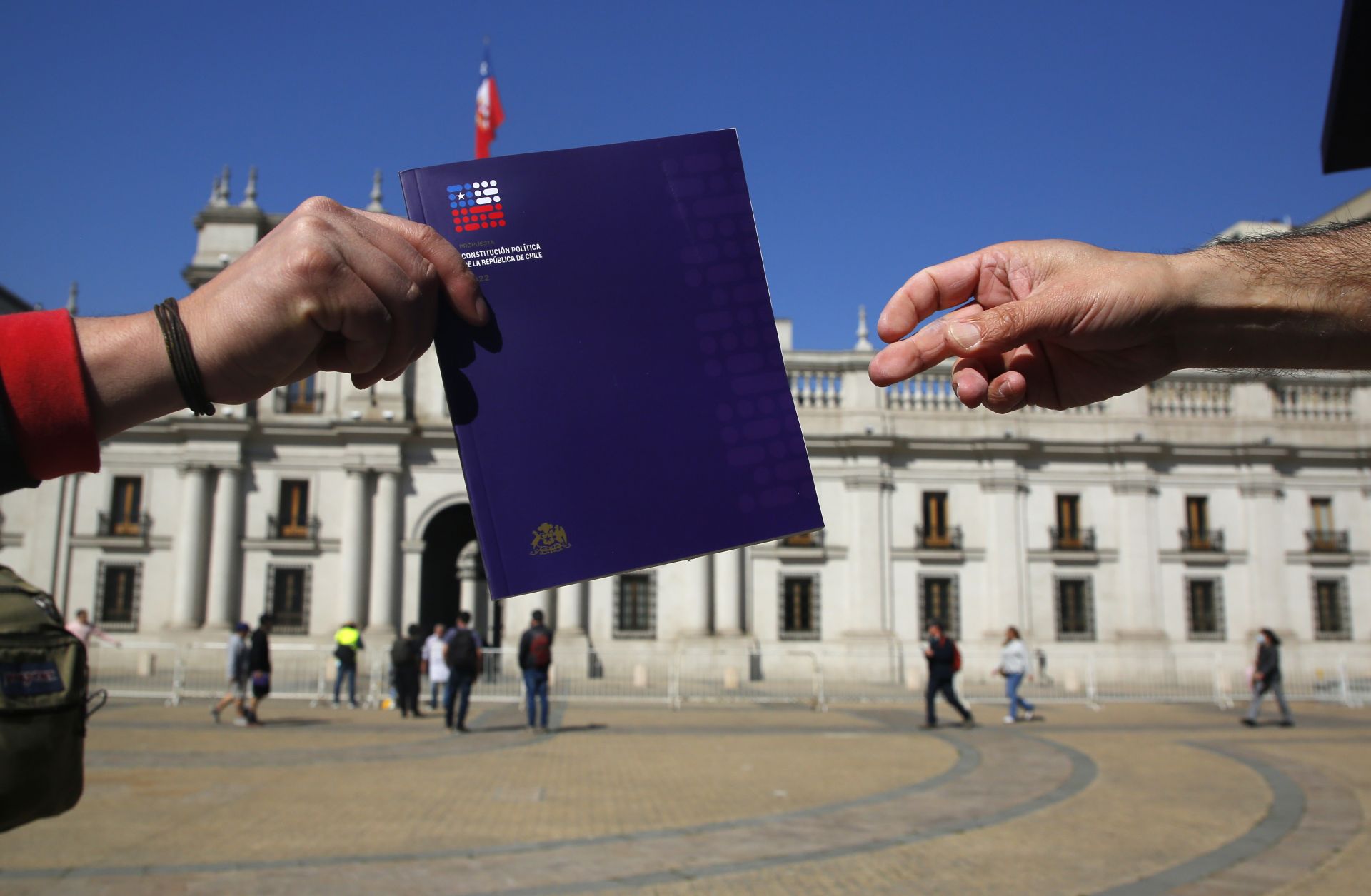 Citizens in Santiago receive a copy of the proposed new Chilean constitution on Aug. 29, 2022, ahead of the upcoming referendum. 