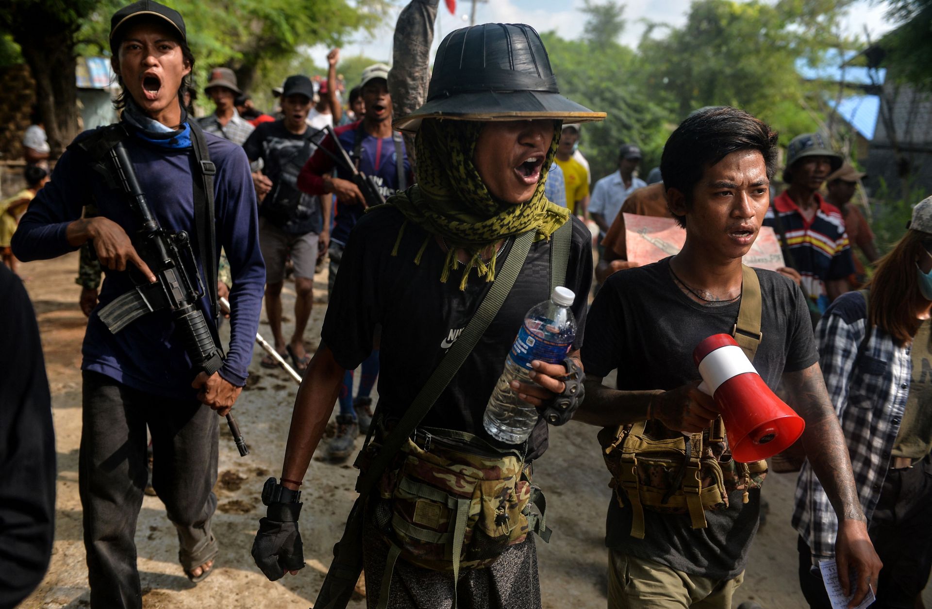 Anti-coup fighters escort protesters as they take part in a demonstration against the military coup in Sagaing, Myanmar, on Sept. 7, 2022. 
