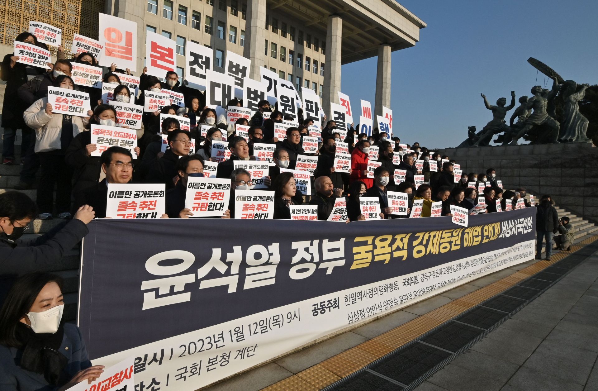South Korean opposition lawmakers and supporters of the victims of Japan's wartime forced labor hold up placards during a protest against a public hearing on the issue at the National Assembly in Seoul on Jan. 12, 2023. South Korean opposition lawmakers and supporters of the victims of Japan's wartime forced labor hold up placards during a protest against a public hearing on the issue at the National Assembly in Seoul on Jan. 12, 2023.