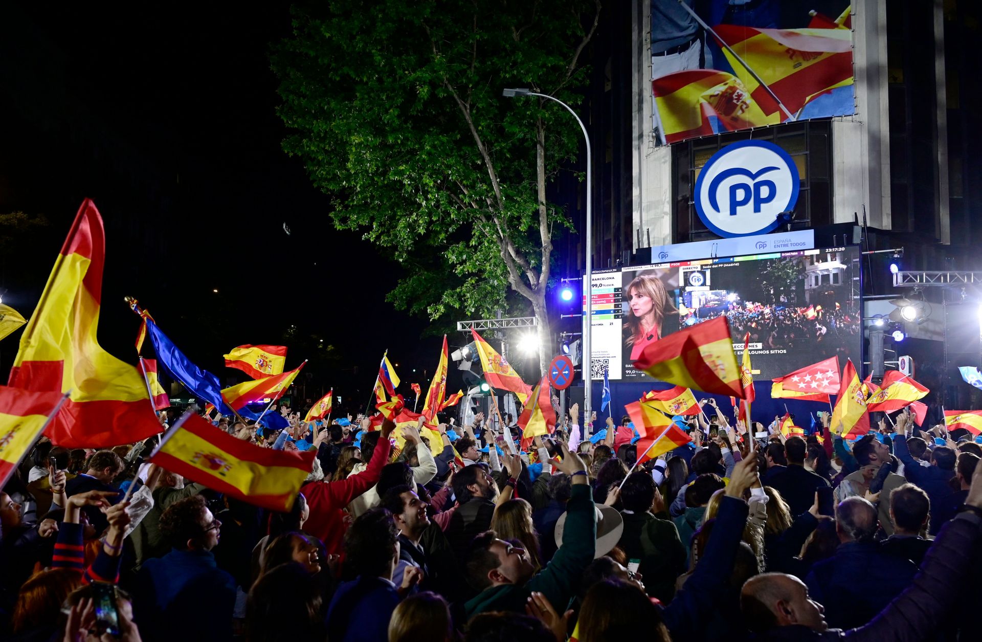 Supporters of Spain's center-right Popular Party (PP) gather outside the PP's headquarters in Madrid on May 28, 2023, to celebrate the party's strong performance in recent regional elections. 