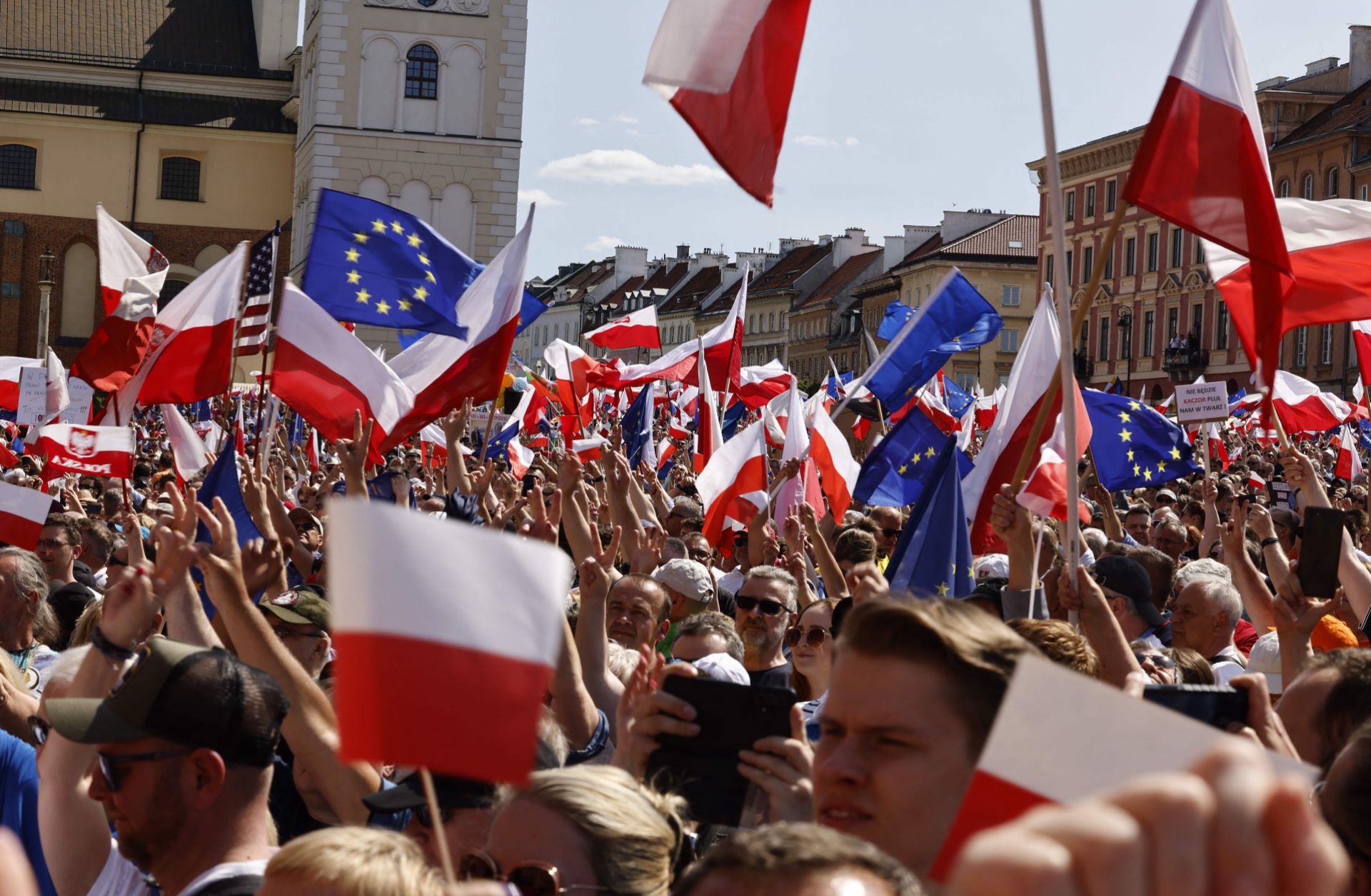 People wave EU and Polish flags during an anti-government rally organized by the opposition in Warsaw, Poland, on June 4, 2023. 