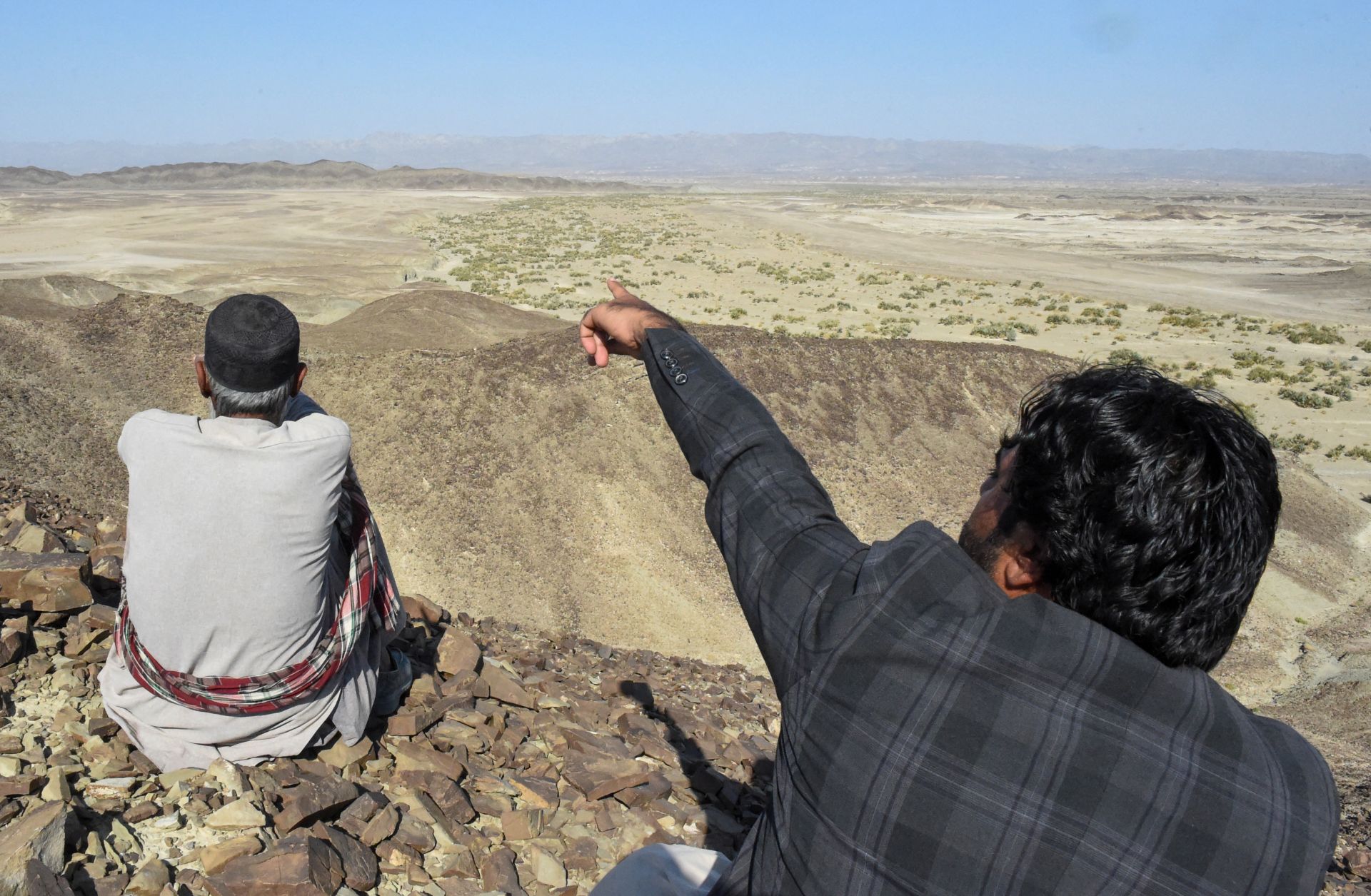 A photo taken on Jan. 18, 2024, shows a resident pointing to a mountain in the Koh-e-Sabz area of Pakistan's southwest Balochistan province where Iran recently launched an airstrike.