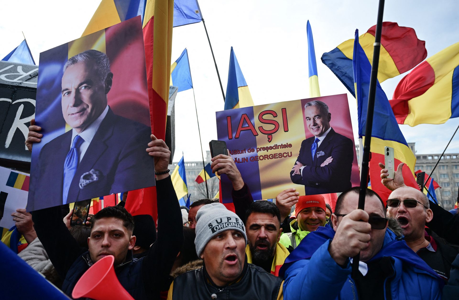 People wave Romanian flags and hold portraits of far-right presidential candidate Calin Georgescu during a protest in front of Romania's Constitutional Court in Bucharest on Jan. 10, 2025. 