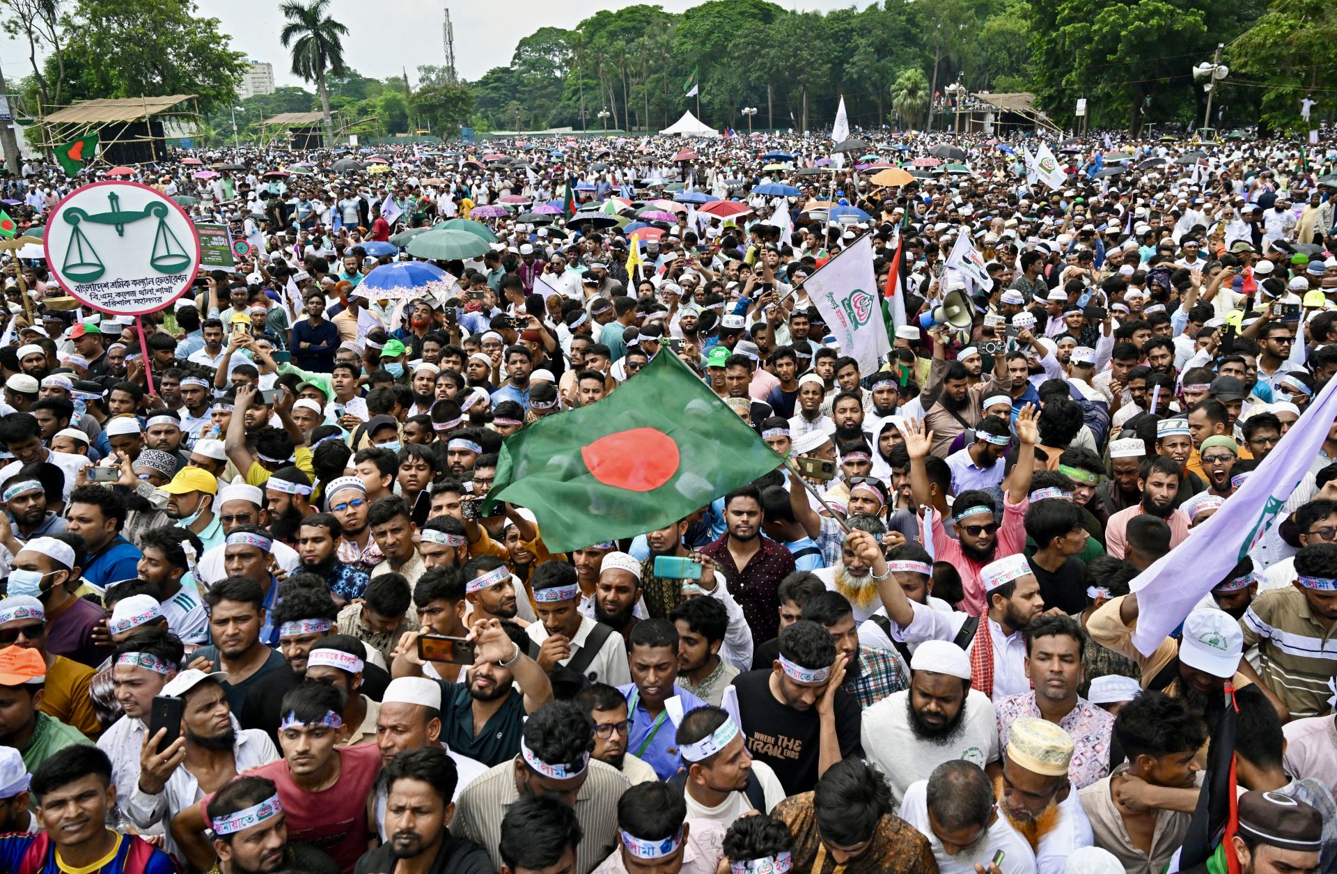 Supporters of Bangladesh's Jamaat-e-Islami party wave the national flag in Dhaka during a rally held to call for the introduction of a proportional representation system in the country's forthcoming general election on July 19, 2025. 