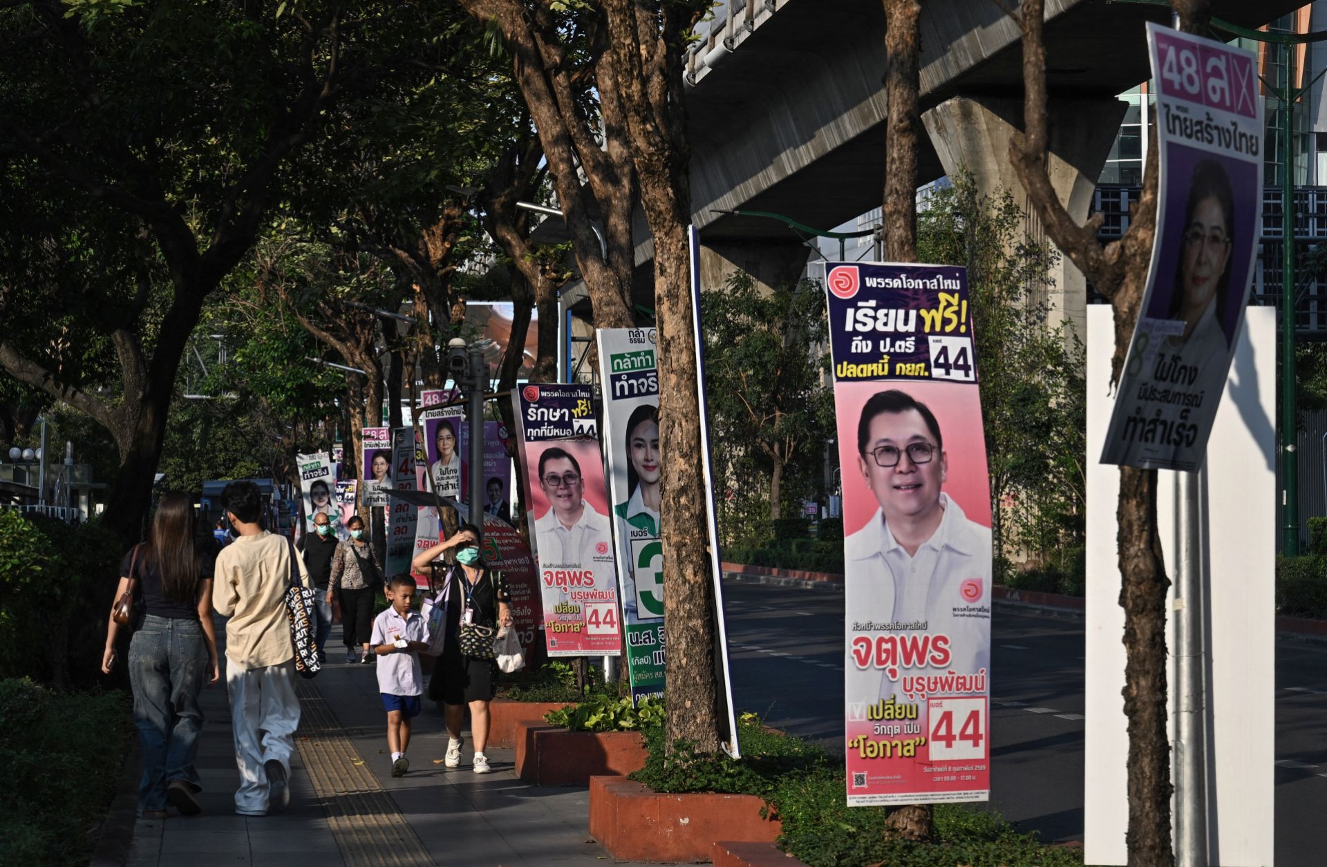 People walk past campaign posters in Bangkok on Feb. 2, 2026, ahead of Thailand's Feb. 8 general election.