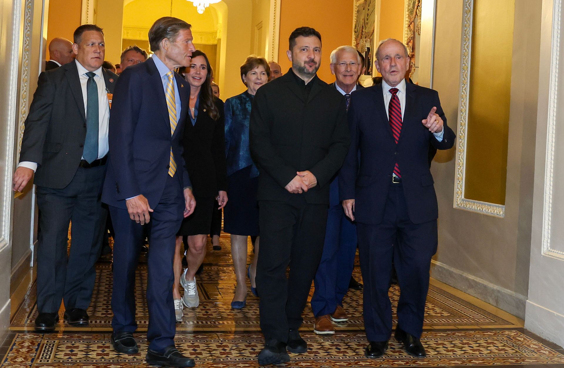 Ukrainian President Volodymyr Zelensky (center) chats with U.S. senators before heading to a closed-door meeting at the U.S. Capitol on July 28, 2026. 
