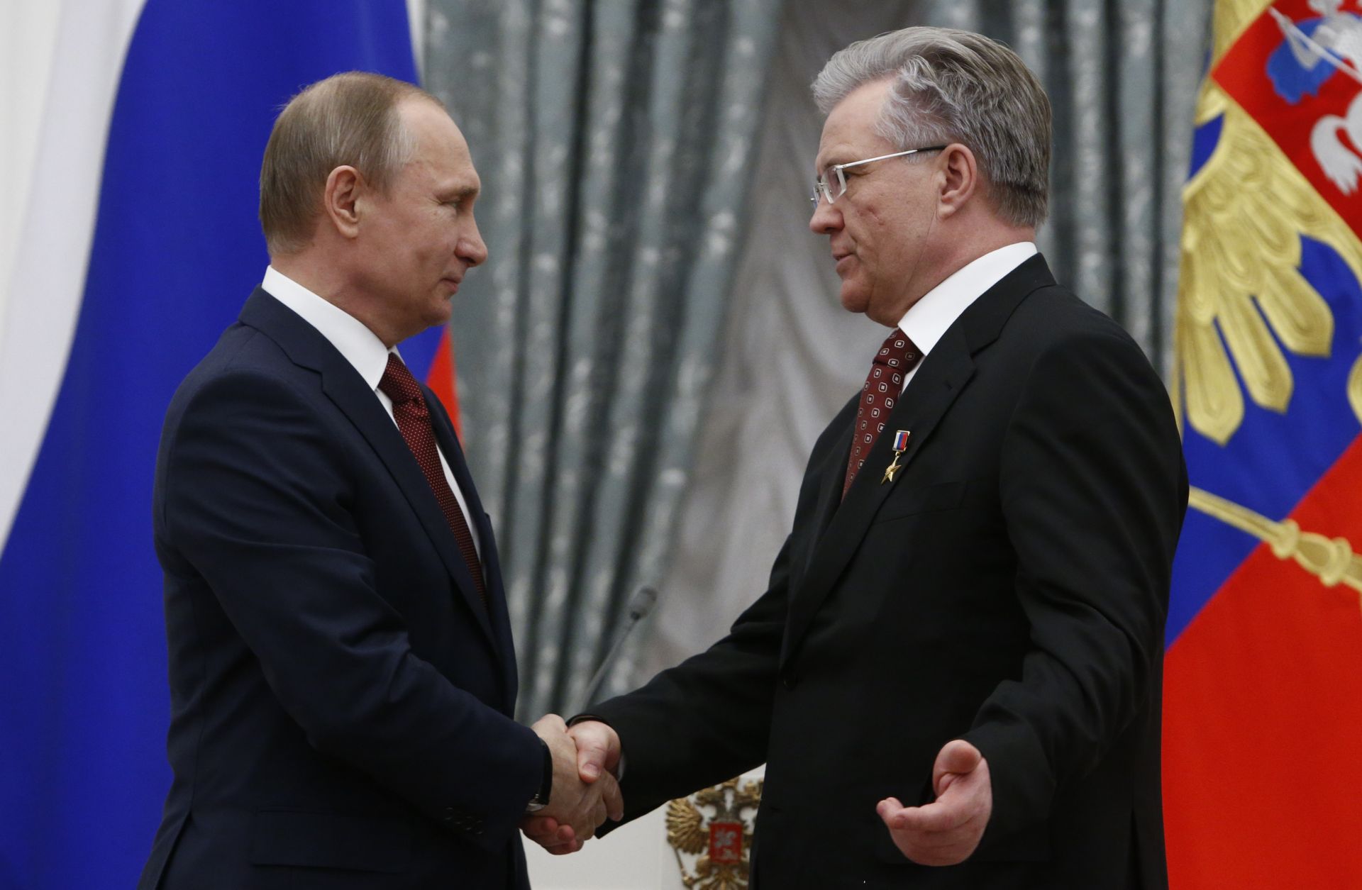 Russian President Vladimir Putin (left) shakes hands with Vladimir Bogdanov, CEO of Surgutneftegas oil and gas company, in Moscow on April 30, 2016.