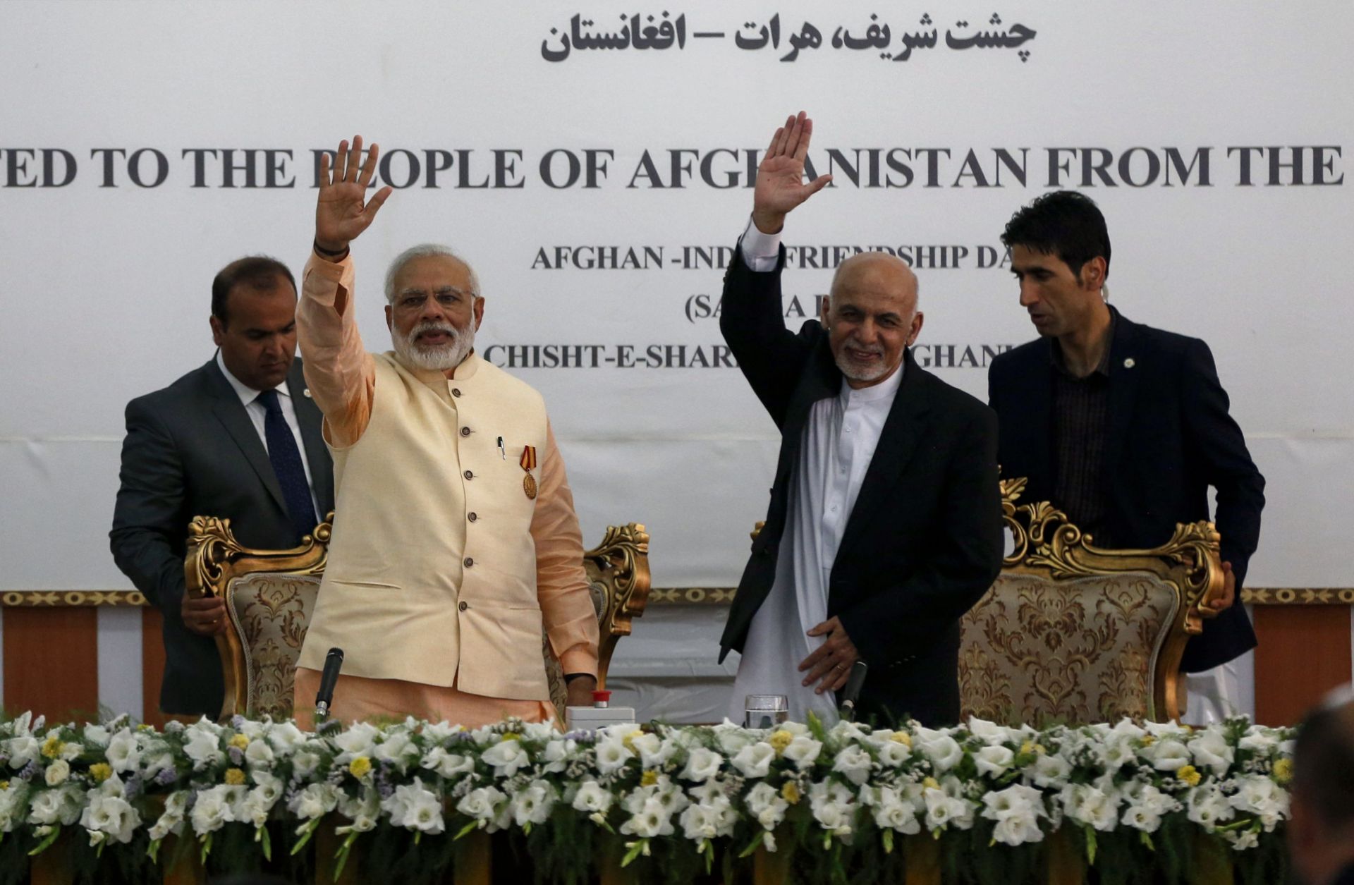 Indian Prime Minister Narendra Modi (left) and then-Afghan President Ashraf Ghani wave during the inauguration of the Afghan-India Friendship Dam in Herat, Afghanistan, on June 4, 2016. 