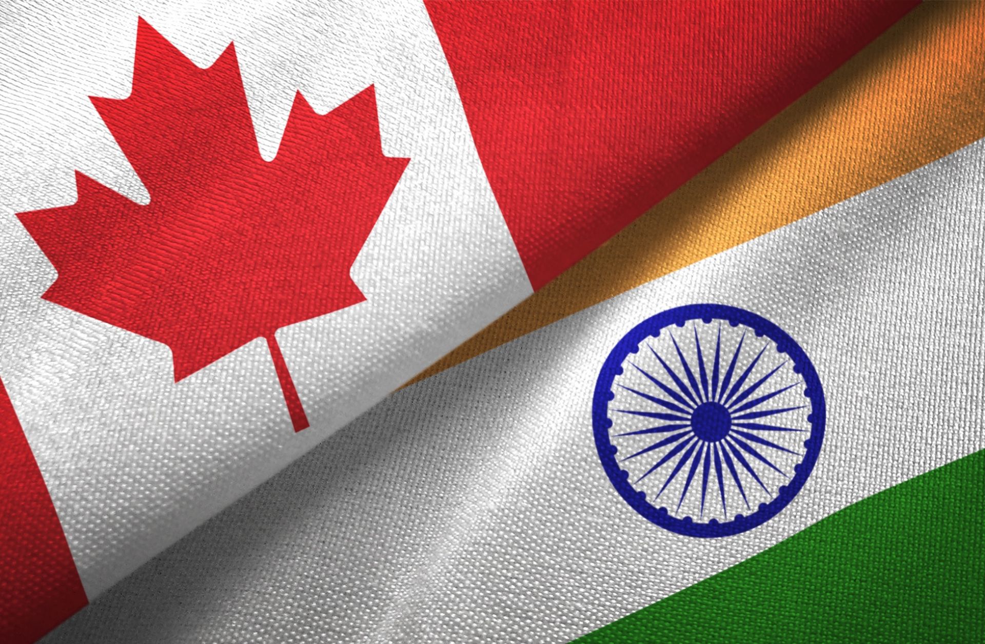 A digital illustration of the Indian and Canadian flags. A digital illustration of the Indian and Canadian flags.