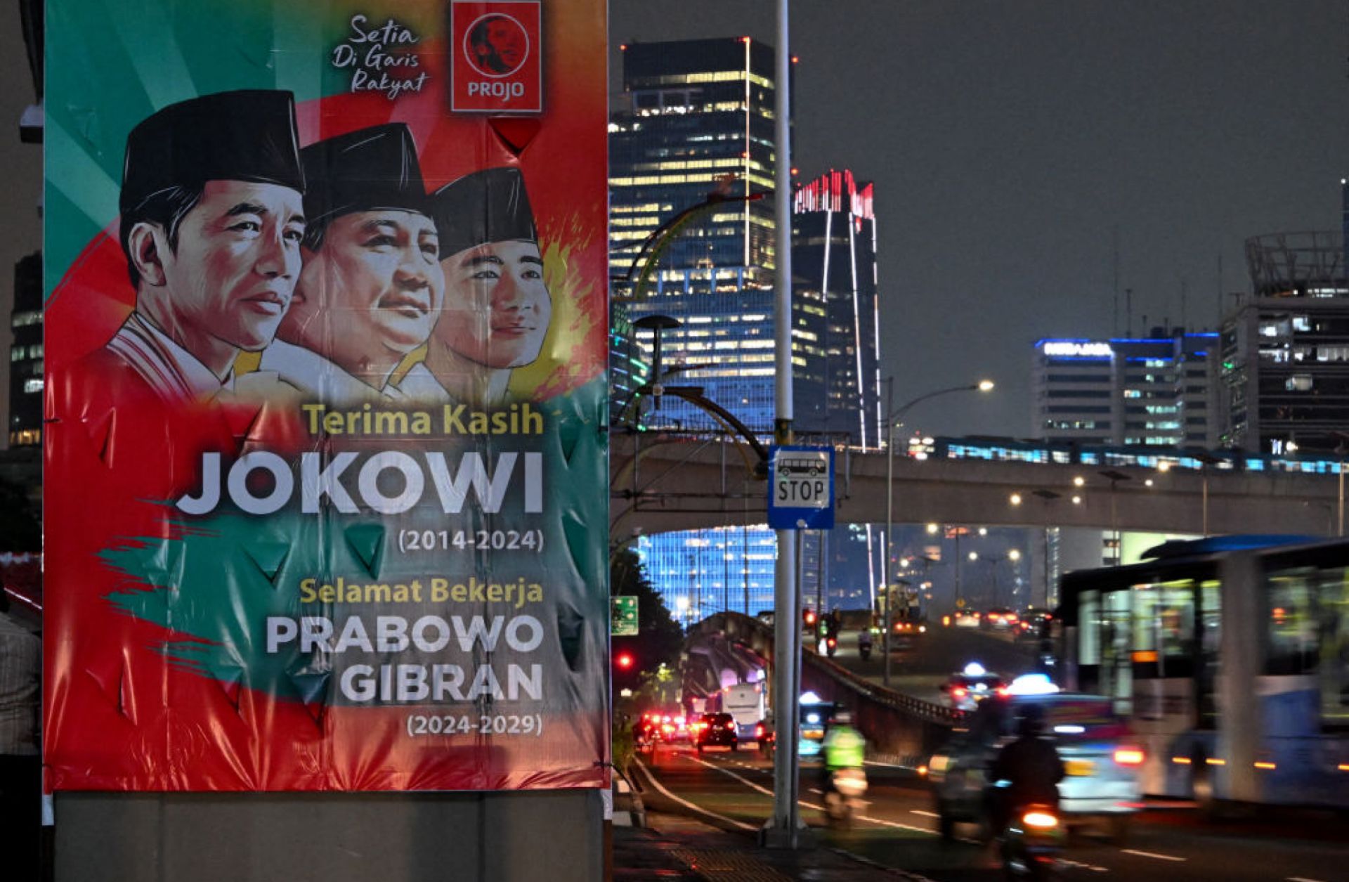 Vehicles pass by a banner thanking outgoing Indonesian President Joko "Jokowi" Widodo and congratulating President-elect Prabowo Subianto and Vice President-elect Gibran Rakabuming Raka ahead of their Oct. 20 inauguration in Jakarta, Indonesia, on Oct. 17, 2024.