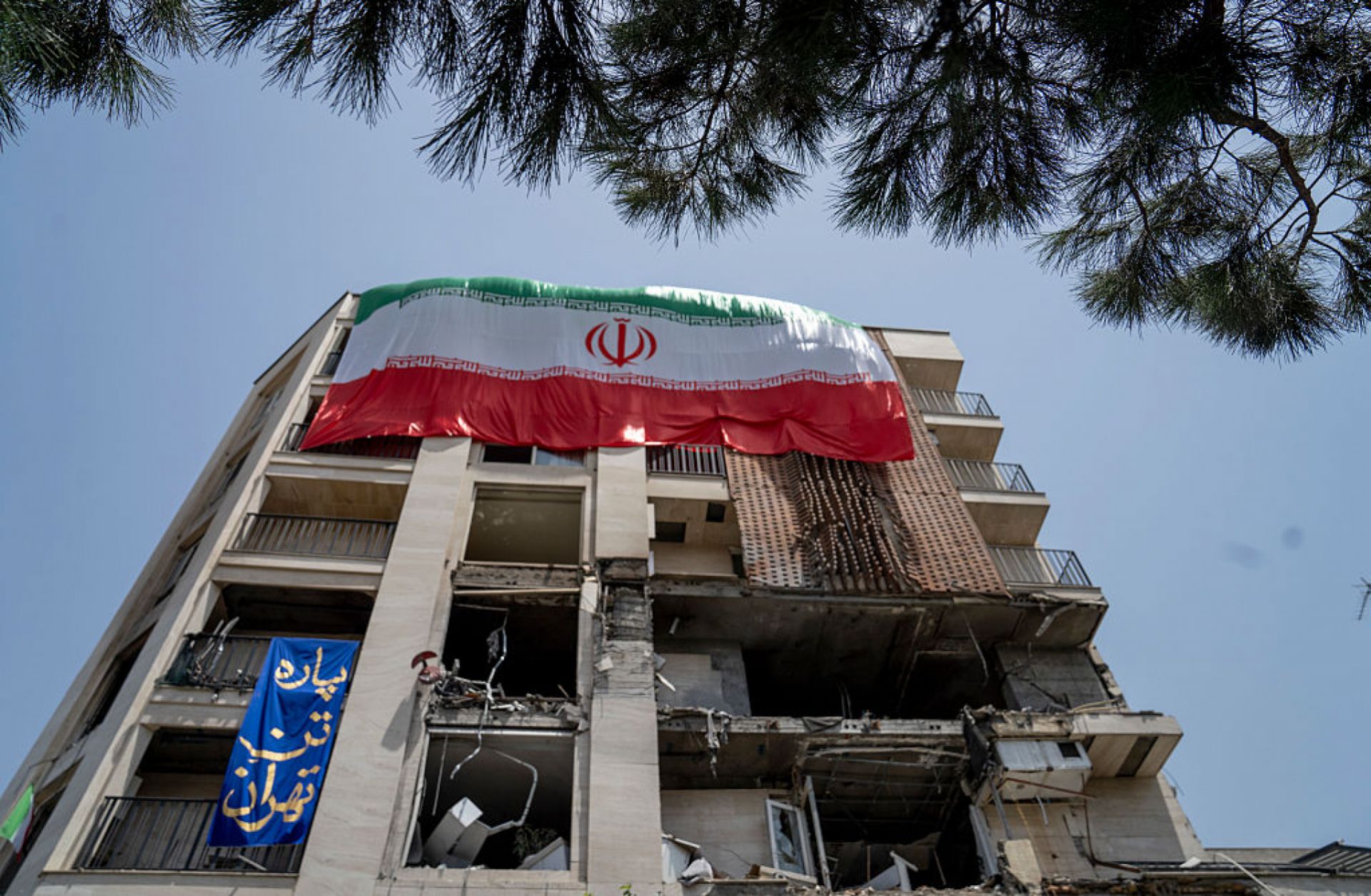 An Iranian flag is draped from a building damaged during a recent attack by Israel is seen in the Gisha neighborhood of Tehran, Iran, on June 25, 2025. 