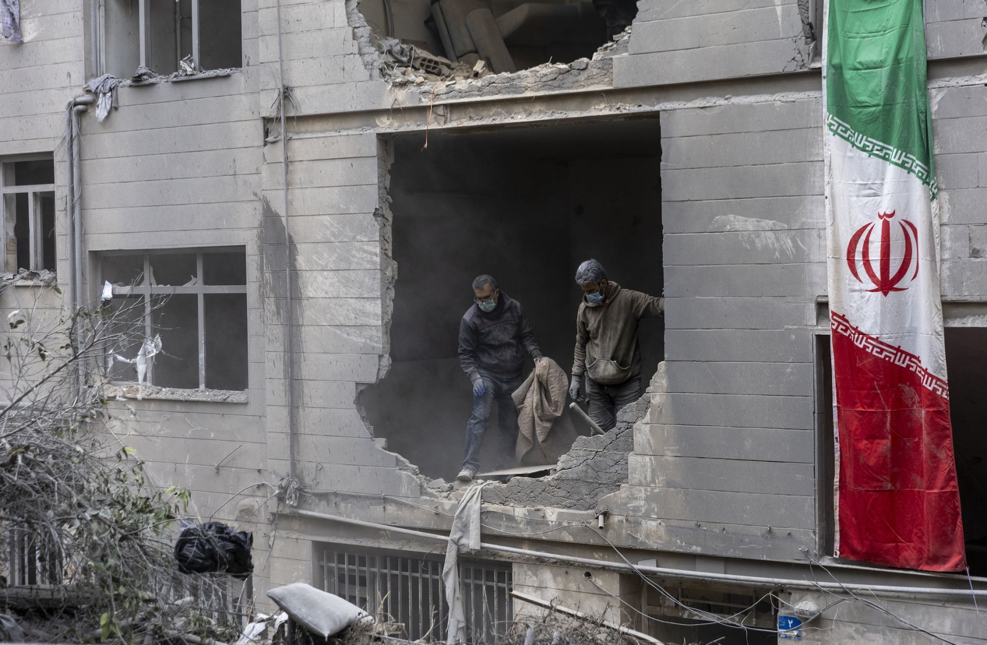 People on March 15 in Tehran, Iran, clean up rubble from a missile attack.