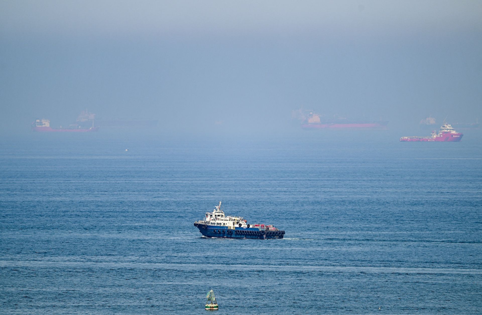 Cargo ships June 19 off the coast of the Khor Fakkan Container Terminal in Sharjah emirate, along the Gulf of Oman. On the heels of growing domestic political pushback in the United States, Washington and Tehran will enter a second week of the 60-day ceasefire.