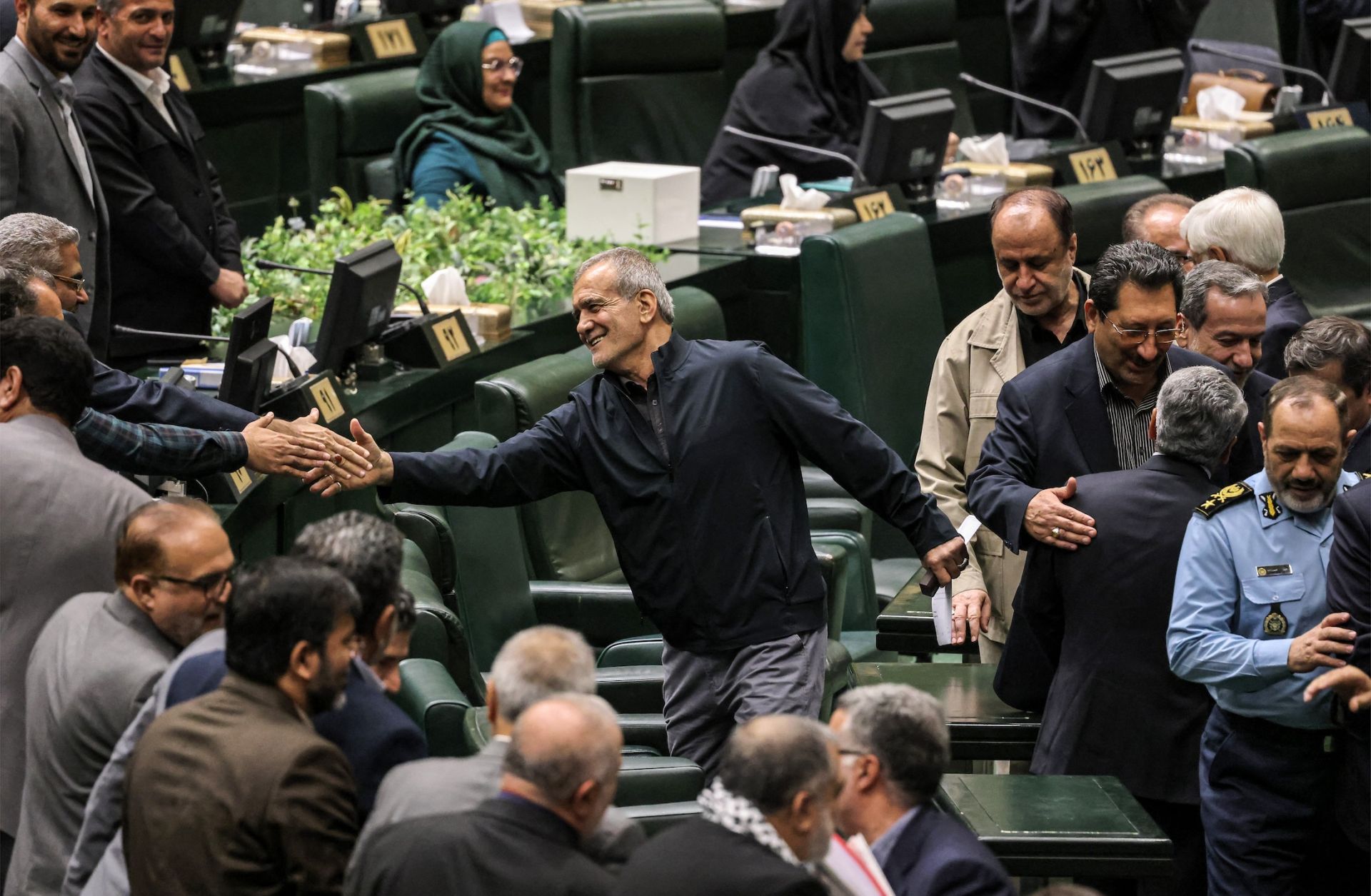 Iran's President Masoud Pezeshkian (C) greets parliament members after giving an address during a session to approve his new Cabinet appointments in Tehran on Aug. 21, 2024. Iran's President Masoud Pezeshkian (C) greets parliament members after giving an address during a session to approve his new Cabinet appointments in Tehran on Aug. 21, 2024.