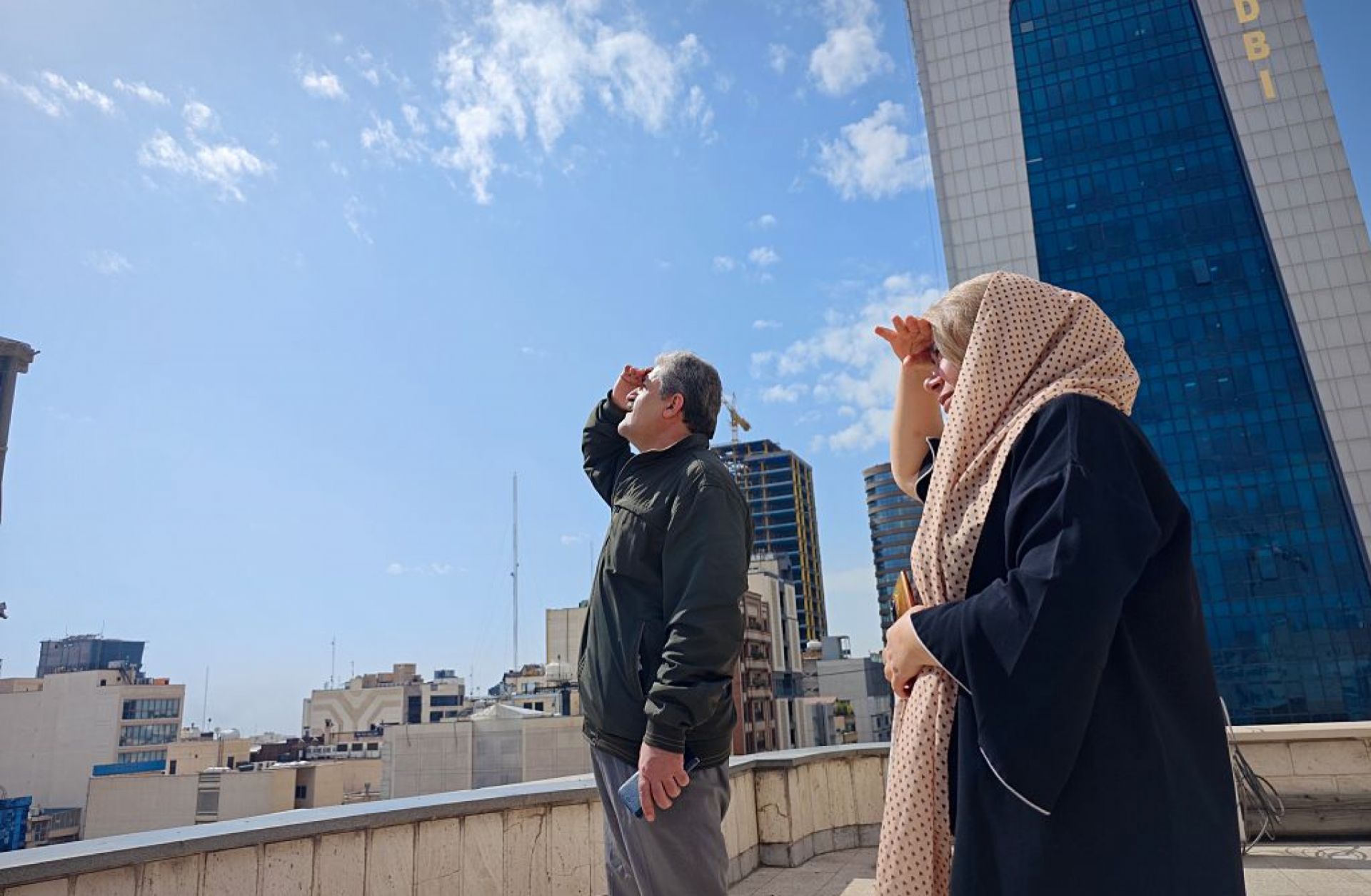 People in Tehran look to the skies from a rooftop amid reports of widespread U.S. and Israeli attacks in Iran on Feb. 28, 2026.