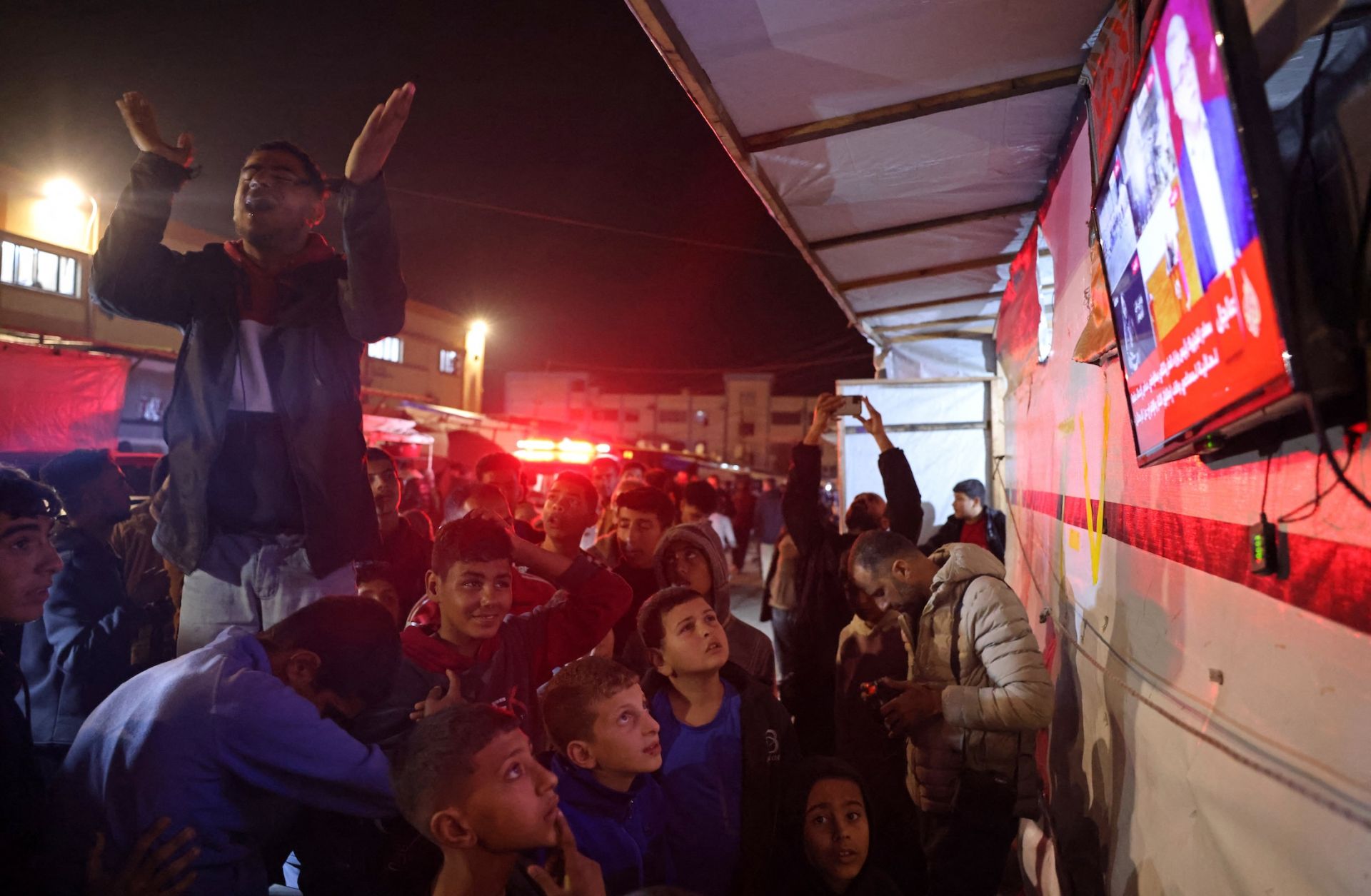 People celebrate while watching news coverage of the Israel-Hamas ceasefire in Khan Yunis in the southern Gaza Strip on Jan. 15, 2025.