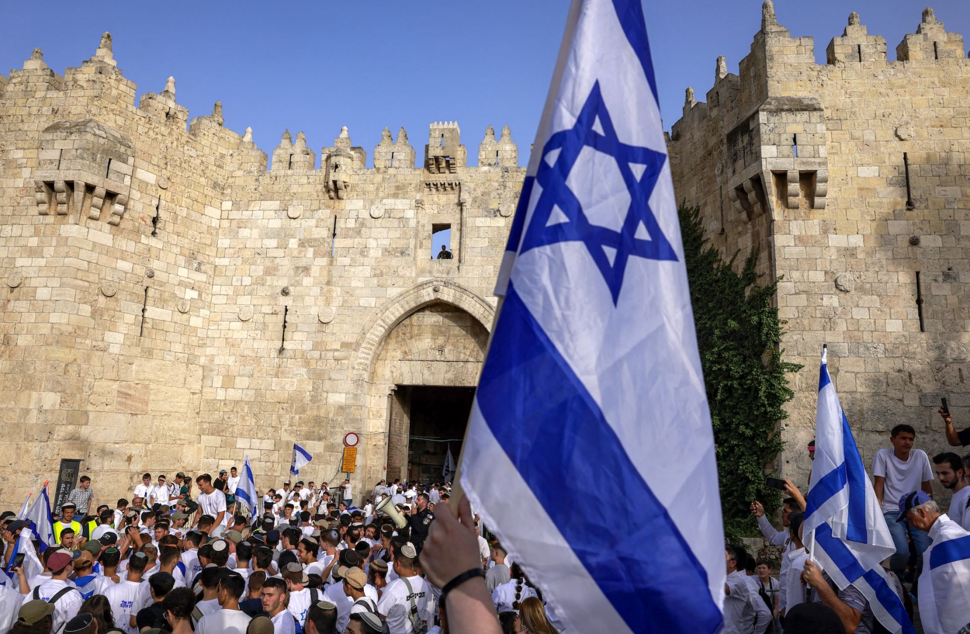 Right-wing activists gather with Israeli flags outside the Damascus Gate of the walled Old City of Jerusalem on May 26, 2025, during a flag march for Jerusalem Day, commemorating the Israeli army's 1967 capture of the city's eastern sector during the Arab-Israeli war.