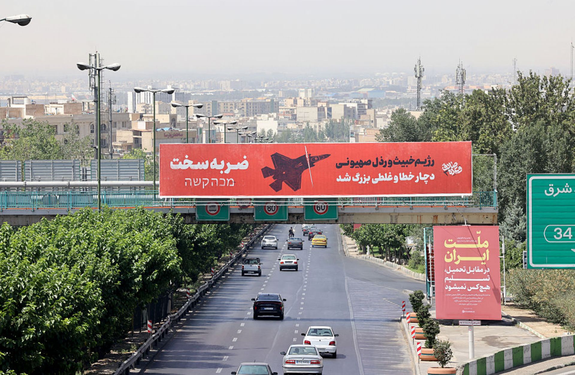 Vehicles drive along a main thoroughfare past a billboard that reads in Farsi and Hebrew: "A severe blow... The vile and villainous Zionist regime (Israel) has made a grave mistake,” in central Tehran on June 24, 2025. Vehicles drive along a main thoroughfare past a billboard that reads in Farsi and Hebrew: "A severe blow... The vile and villainous Zionist regime (Israel) has made a grave mistake,” in central Tehran on June 24, 2025.