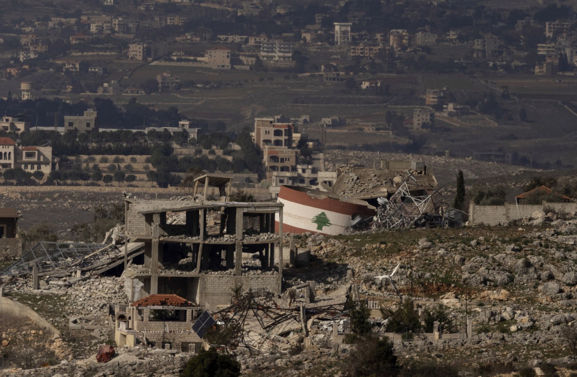 A Lebanese flag painted on a damaged building in a village in southern Lebanon is seen from a position on the Israeli side of the border on Jan. 23, 2025. 