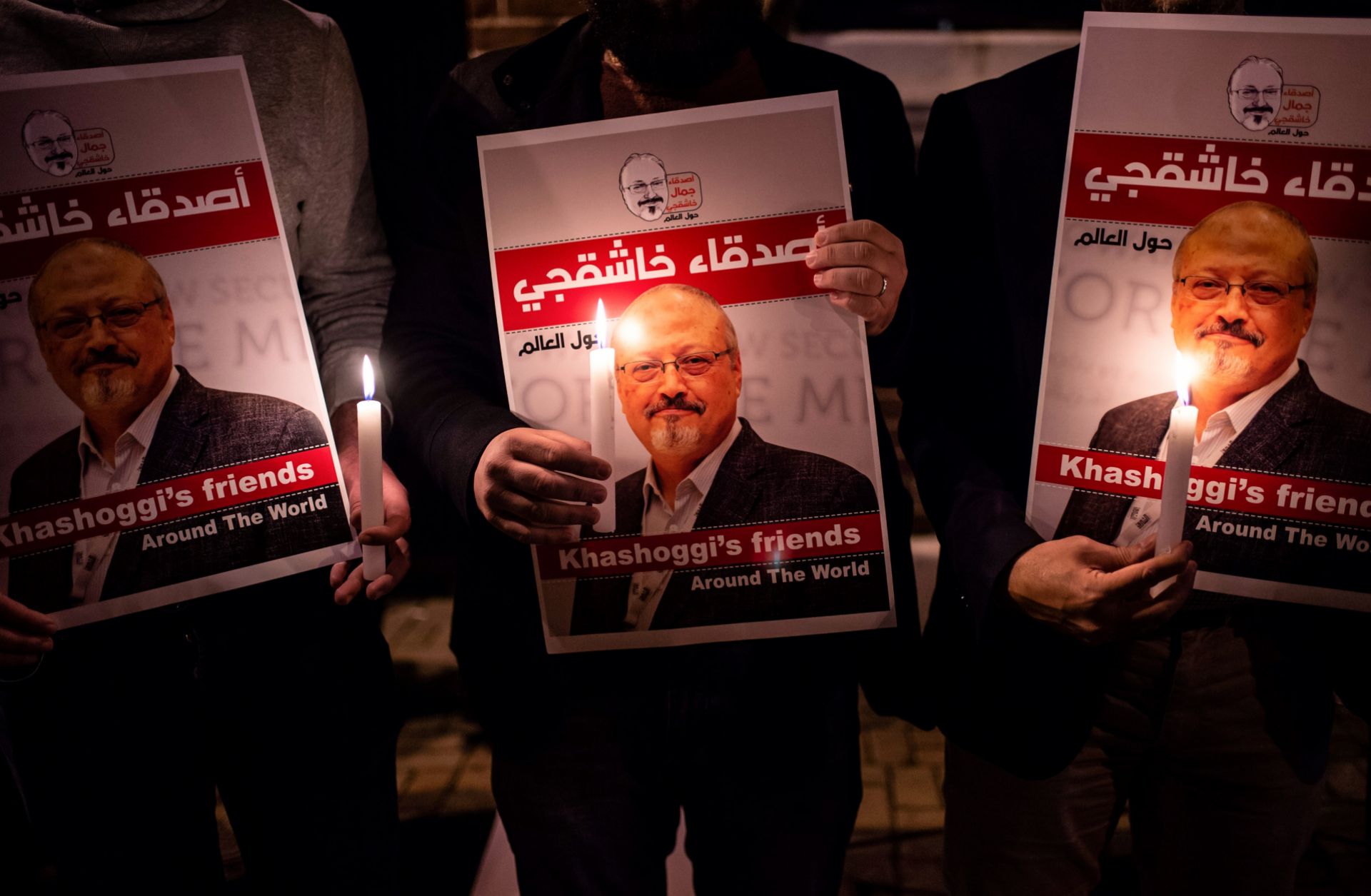 People hold posters depicting murdered Saudi journalist Jamal Khashoggi during a candlelit vigil outside the Saudi consulate in Istanbul on Oct. 25, 2018. 