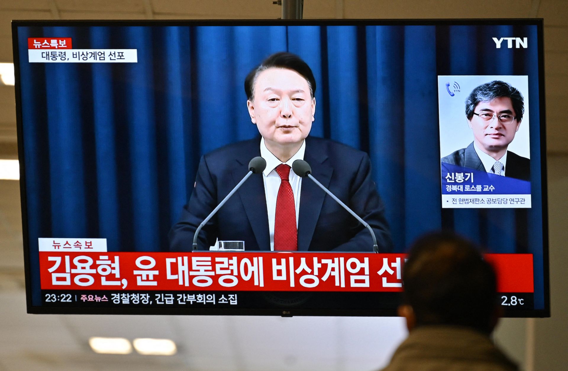 South Korean President Yoon Suk Yeol speaks during a news broadcast on a television at a train station in Seoul on Dec. 3, 2024, after Yoon declared emergency martial law.