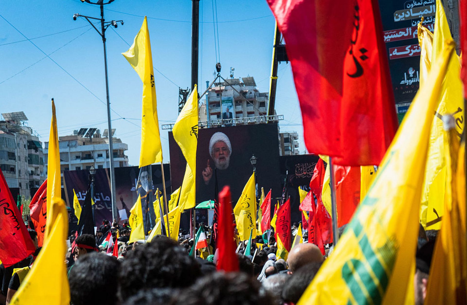 Hezbollah leader Naim Kassem speaks from a stage surrounded by flags in the southern suburbs of Beirut, Lebanon, on July 6, 2025. 