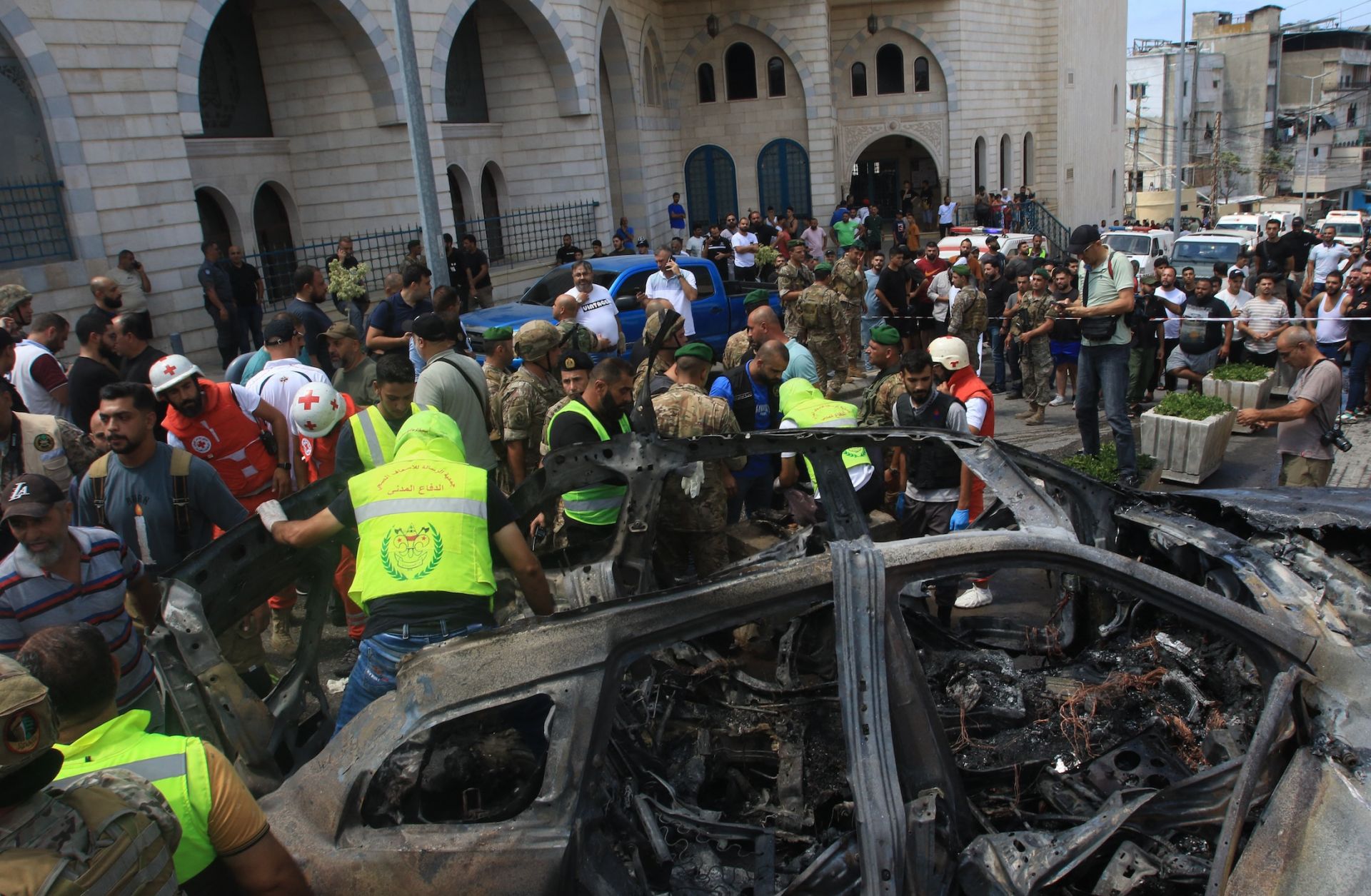 Lebanese authorities inspect a car that was targeted with an Israeli strike and killed a Fatah official in the southern city of Sidon on Aug. 21, 2024. 