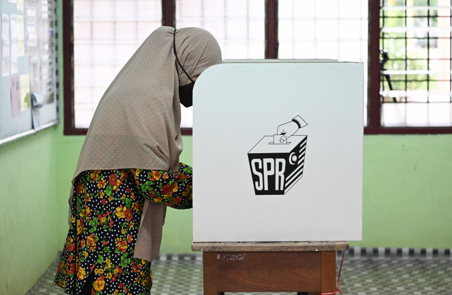 A woman casts a vote at a polling station during Malaysia's general election on Nov. 19, 2022. 