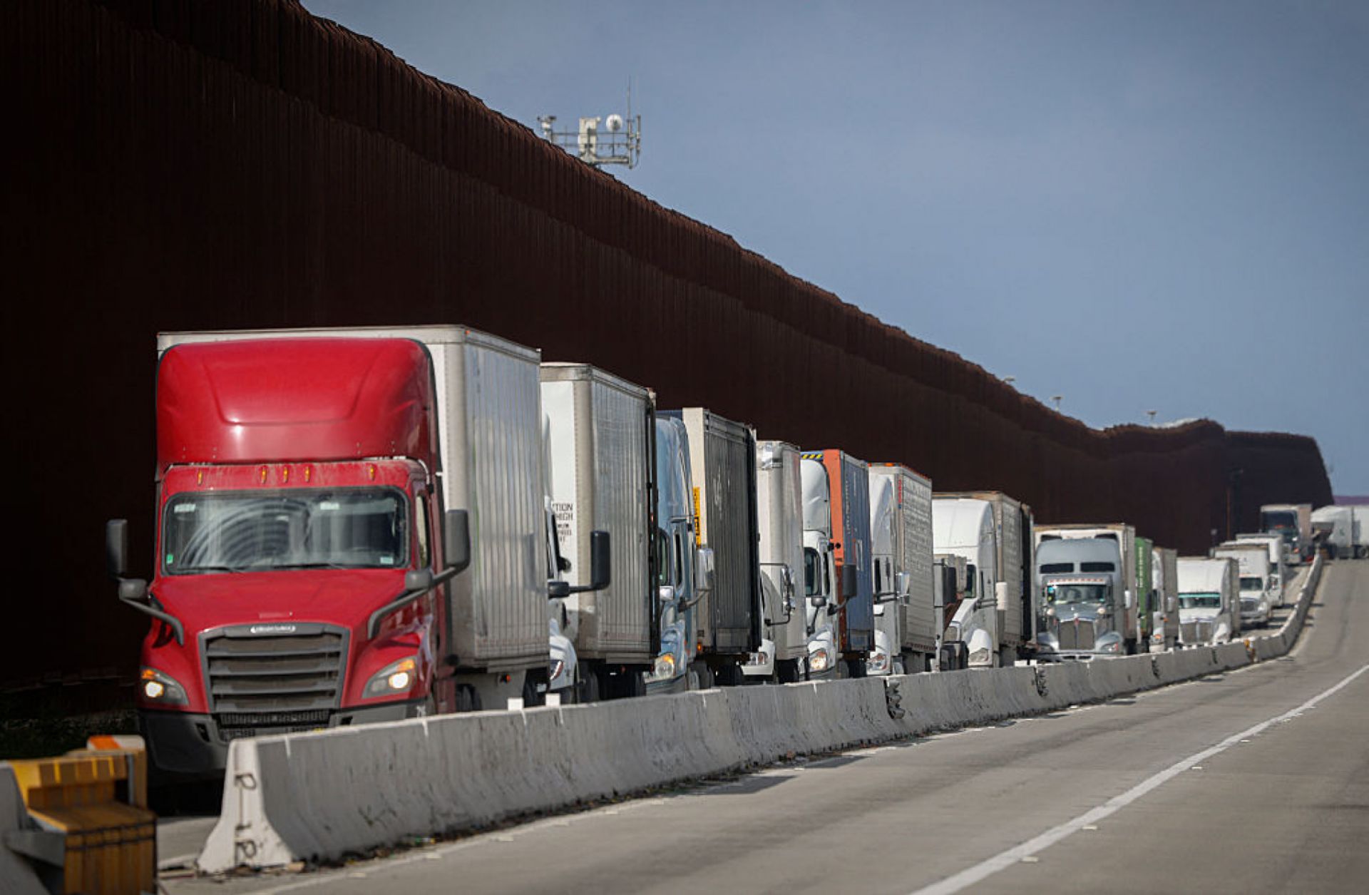 Trucks travel by the U.S.-Mexico border after crossing the border into the United States at Otay Mesa, California, on April 2, 2025. 